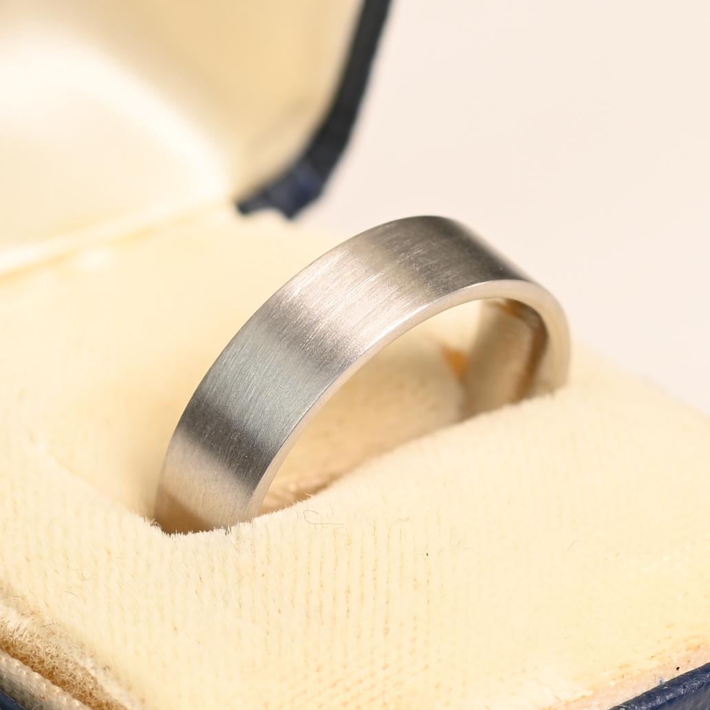 Cette exquise alliance en platine fabriquée à la main est conçue pour être à la fois élégante et confortable. D'une largeur de 6 mm, il présente une finition brossée sophistiquée qui rehausse son attrait intemporel. Méticuleusement fabriquée pour