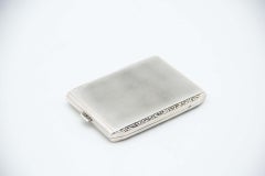 Brushed rectangular silver case with beveled corners and gold interior
