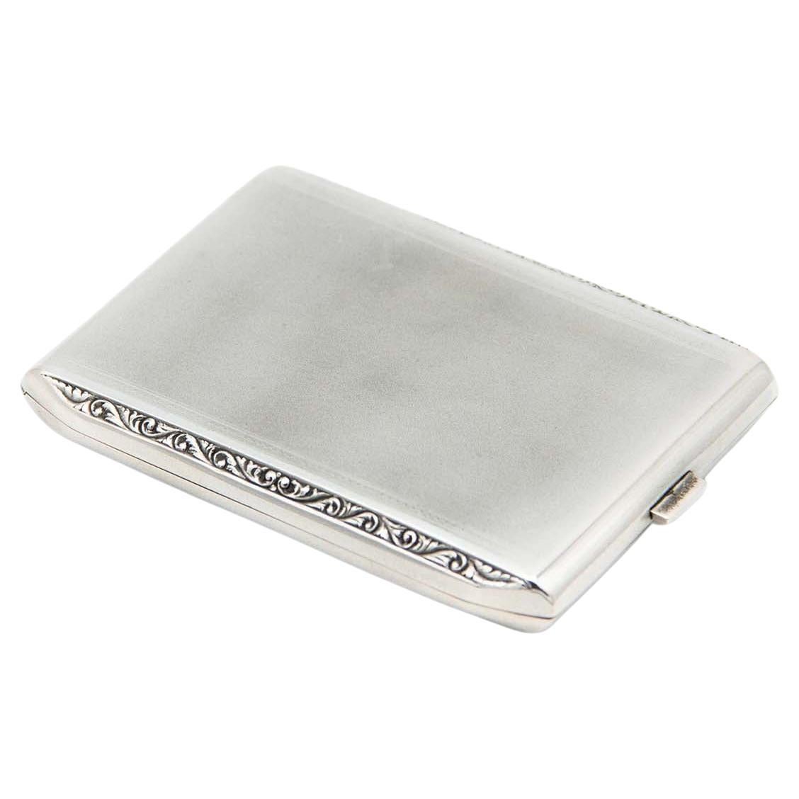 Brushed rectangular silver case with beveled corners and gold interior