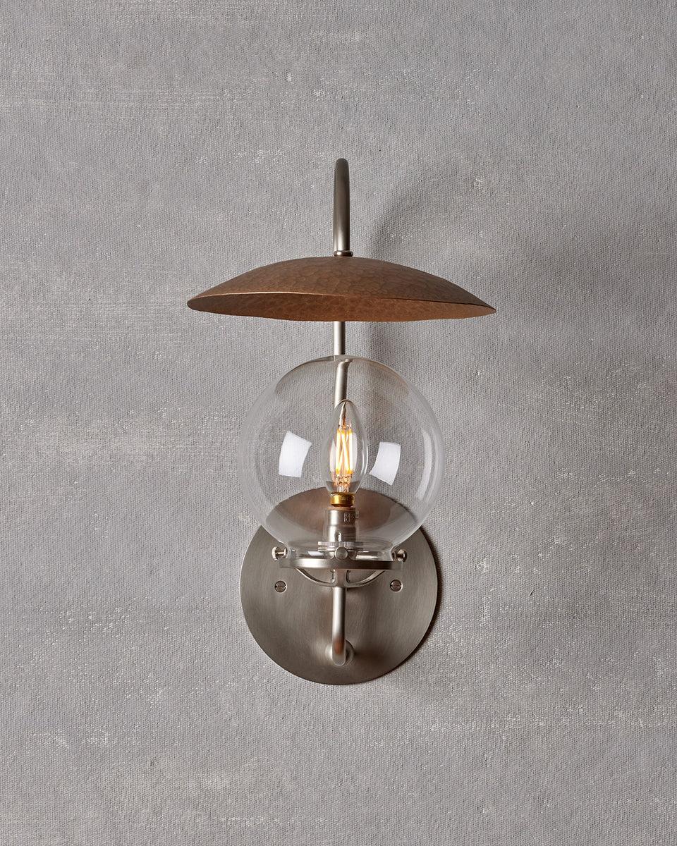 The Mia Sconce is capped with a suspended hand-hammered bronze shade that reflects a warm glow.

OVERALL DIMENSIONS
8.5