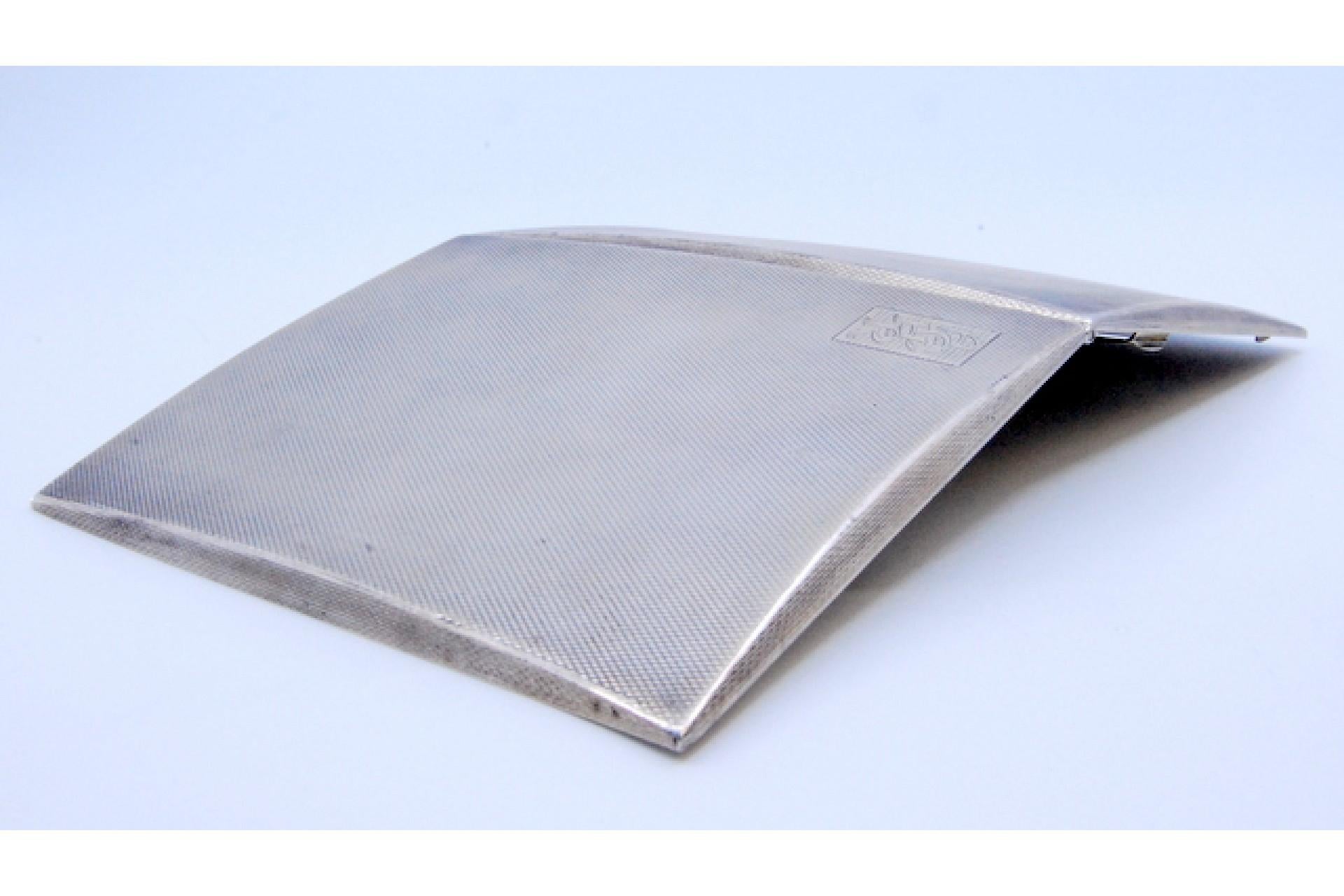 Description: Brushed silver cigarette case with interior cigarette holder, monogrammed screen and hinged lid. Metal: Silver. Origin: English. Brand: Chester. Weight: 173.63 grams. Dimensions: 11.3x8.5cm. Content: 925/1000. Assay Mark: Yes, 1935 by