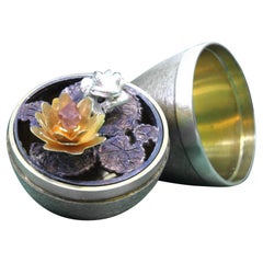 Brushed silver egg with gold-plated frog and gold flower inside, Fabergé style