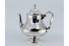 Brushed silver teapot with smooth trim on the surround and knob on the lid