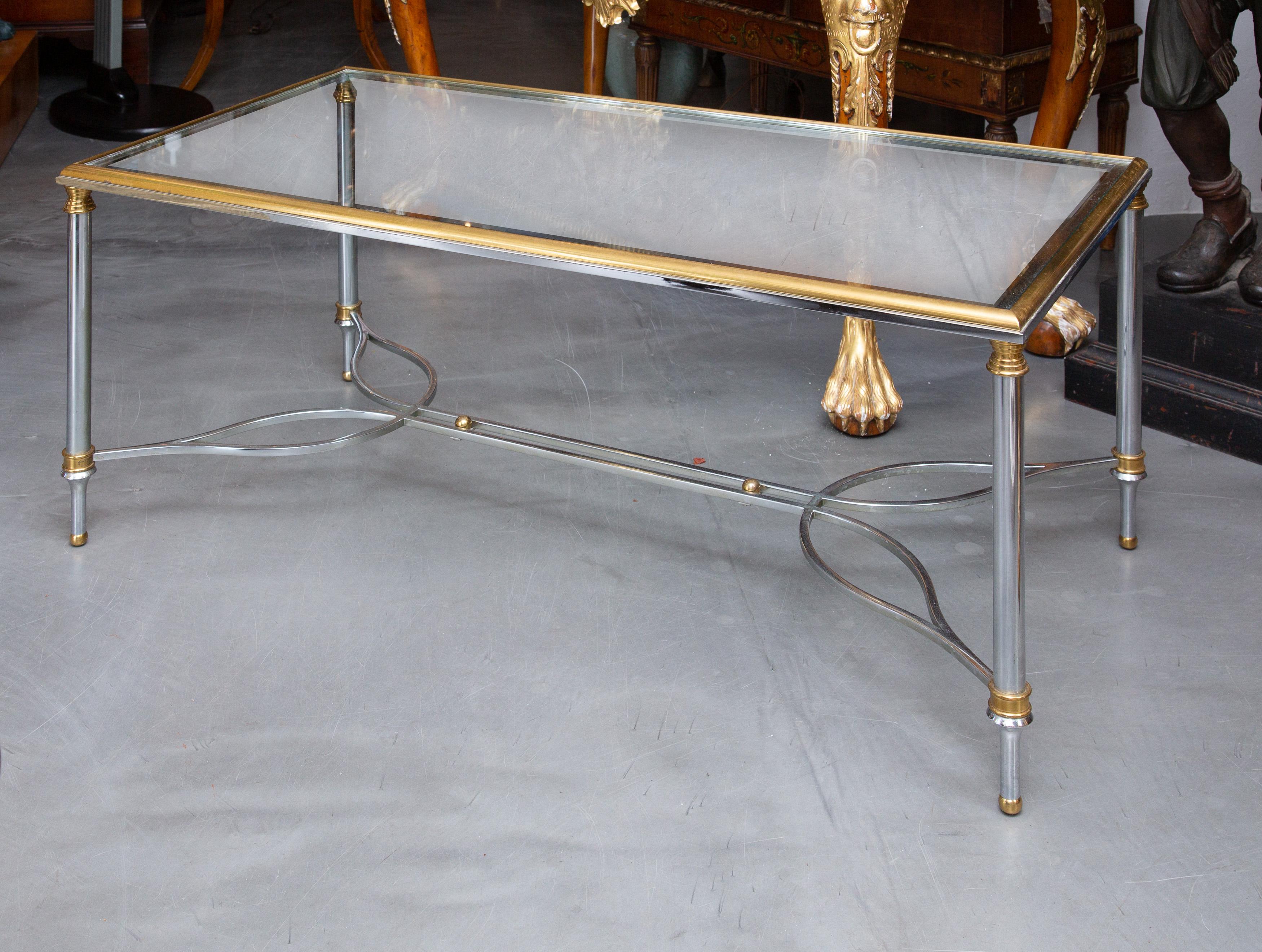 This a sophisticated brushed steel and brass glass top coffee table, attributed to Maison Jansen, based on quality, design and materials, circa 1950.