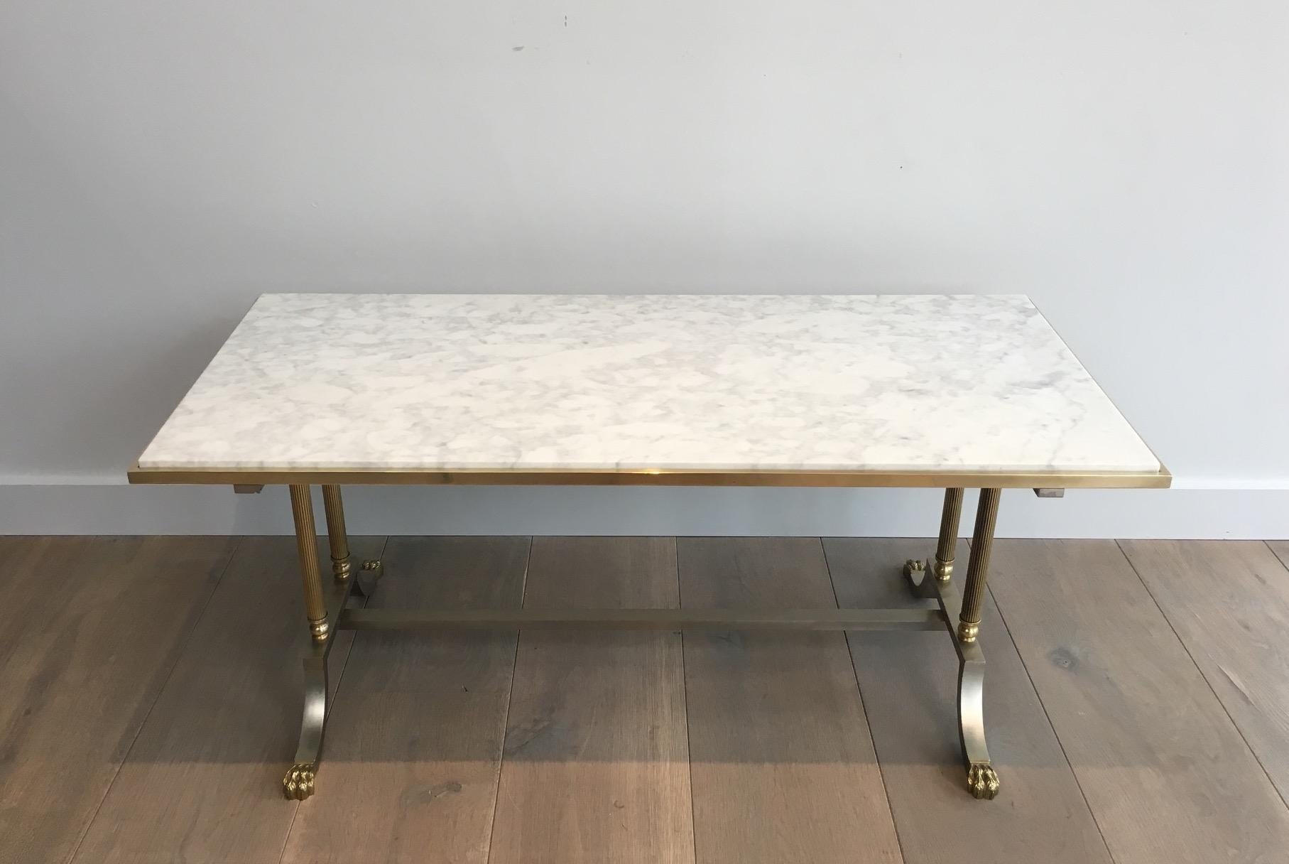 This very nice neoclassical coffee table is made of a brushed steel base with bronze claw feet and brass columns. The top is made of a white Carrare marble. This is a beautiful model from Maison Jansen. French, circa 1940.