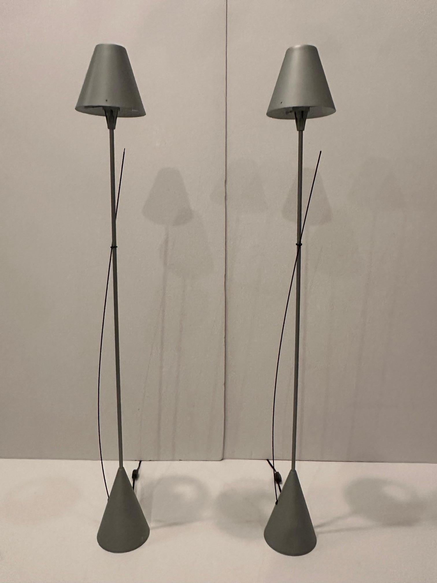 
Very chic pair of elongated tall skinny brushed steel table lamps having conical base, black stylized steel wheat sheaf decoration, and sexy steel shades.
Takes halogen bulbs.