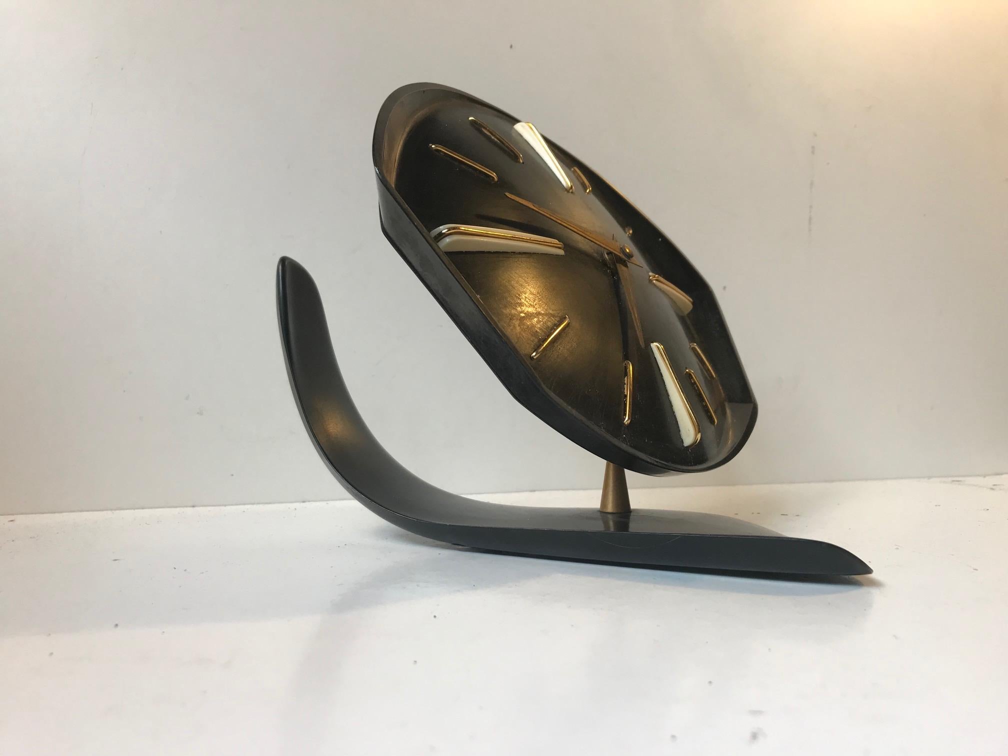 Vintage table clock manufactured by PRIM Clocks in the 1950s. Made of black Bakelite, the clock top is adjustable, standing on a brass ball. Original brass details and hands set on a black Bakelite clock face with beautiful details and lines typical