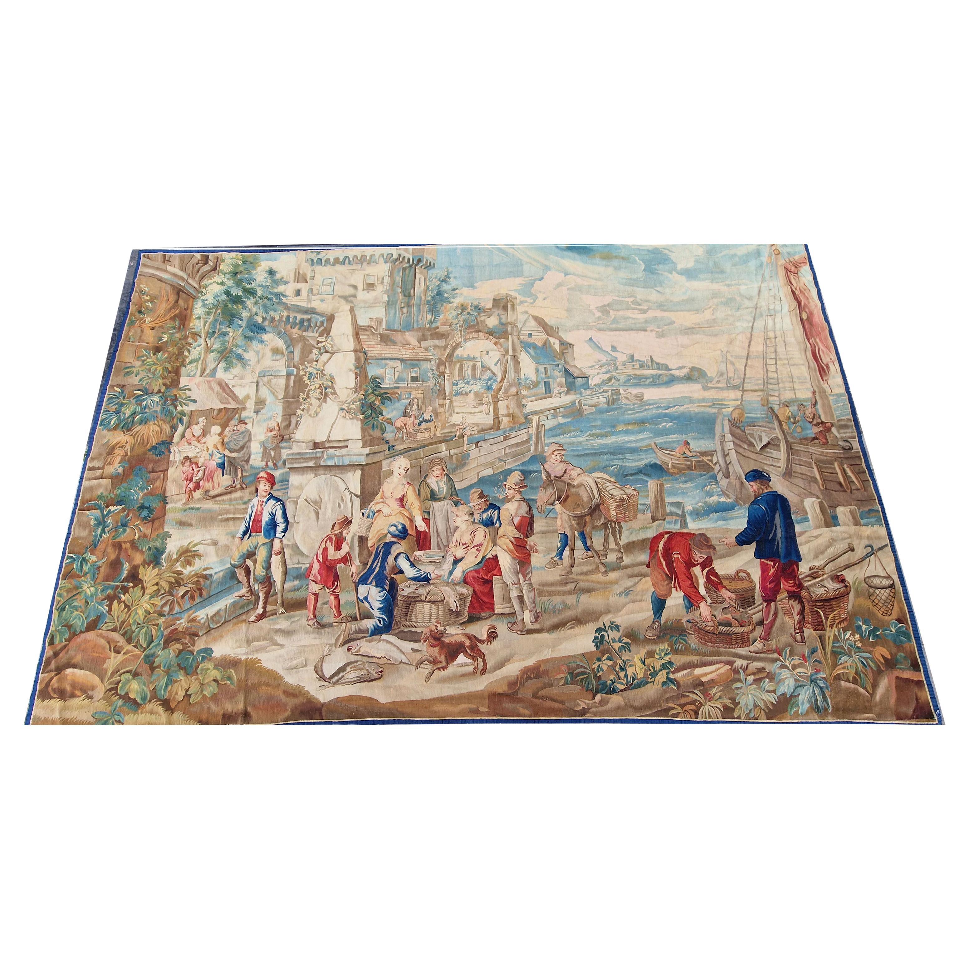 Brussels Circa 1750-Probably woven by Francois Van Der Borcht 1720-1765-Tenier's Style-A placid harbor with a perspectival weighted fortified city scape to left and a stone quay in the foreground with fish mongers and bargaining buyers, along with a