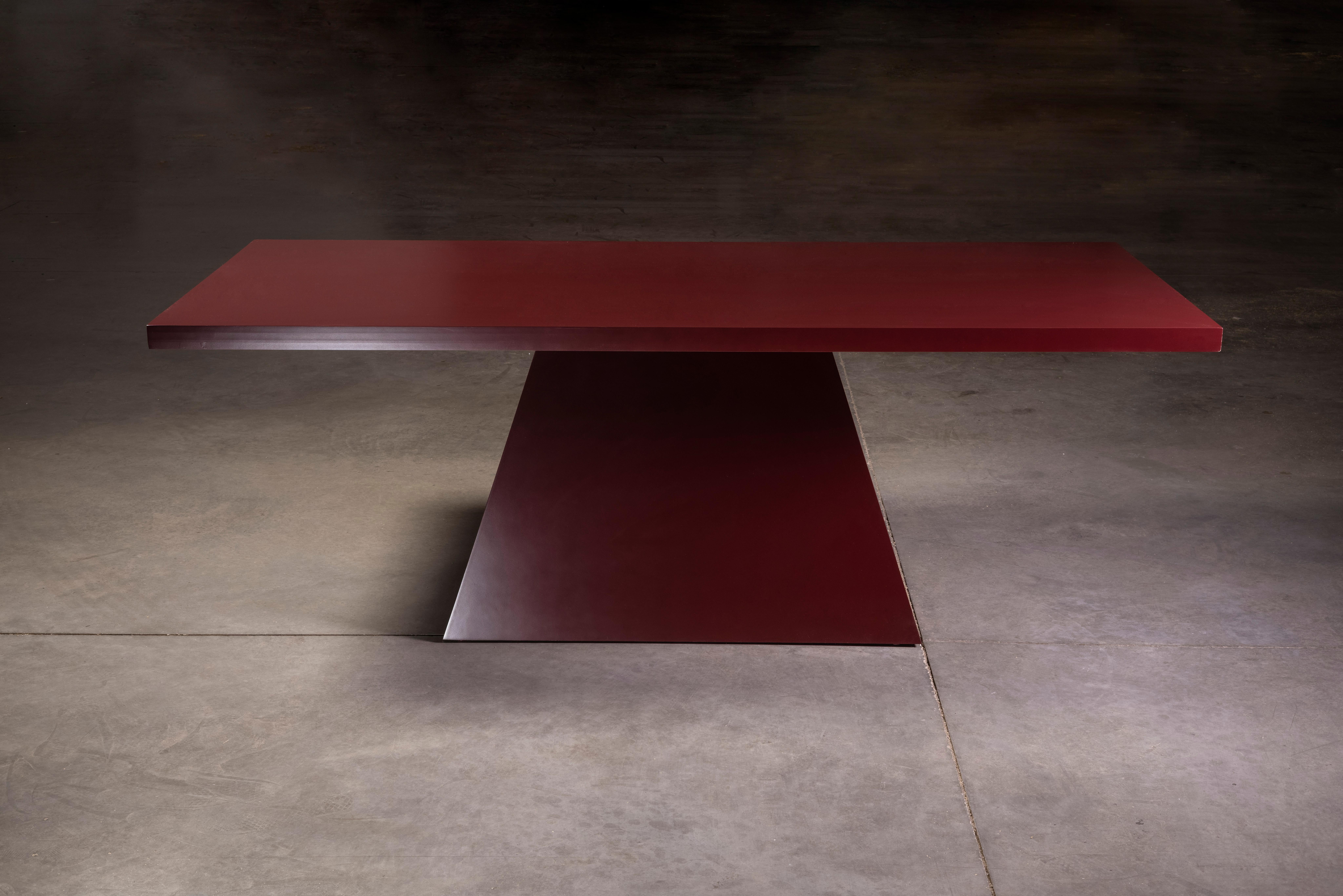 Mesa de comedor maciza, moderna y lacada, con acabado liso rojo oscuro y pedestal triangular.

Hecho a mano por artesanos mexicanos.

Inspirado en el movimiento Brutalista de los años 70.