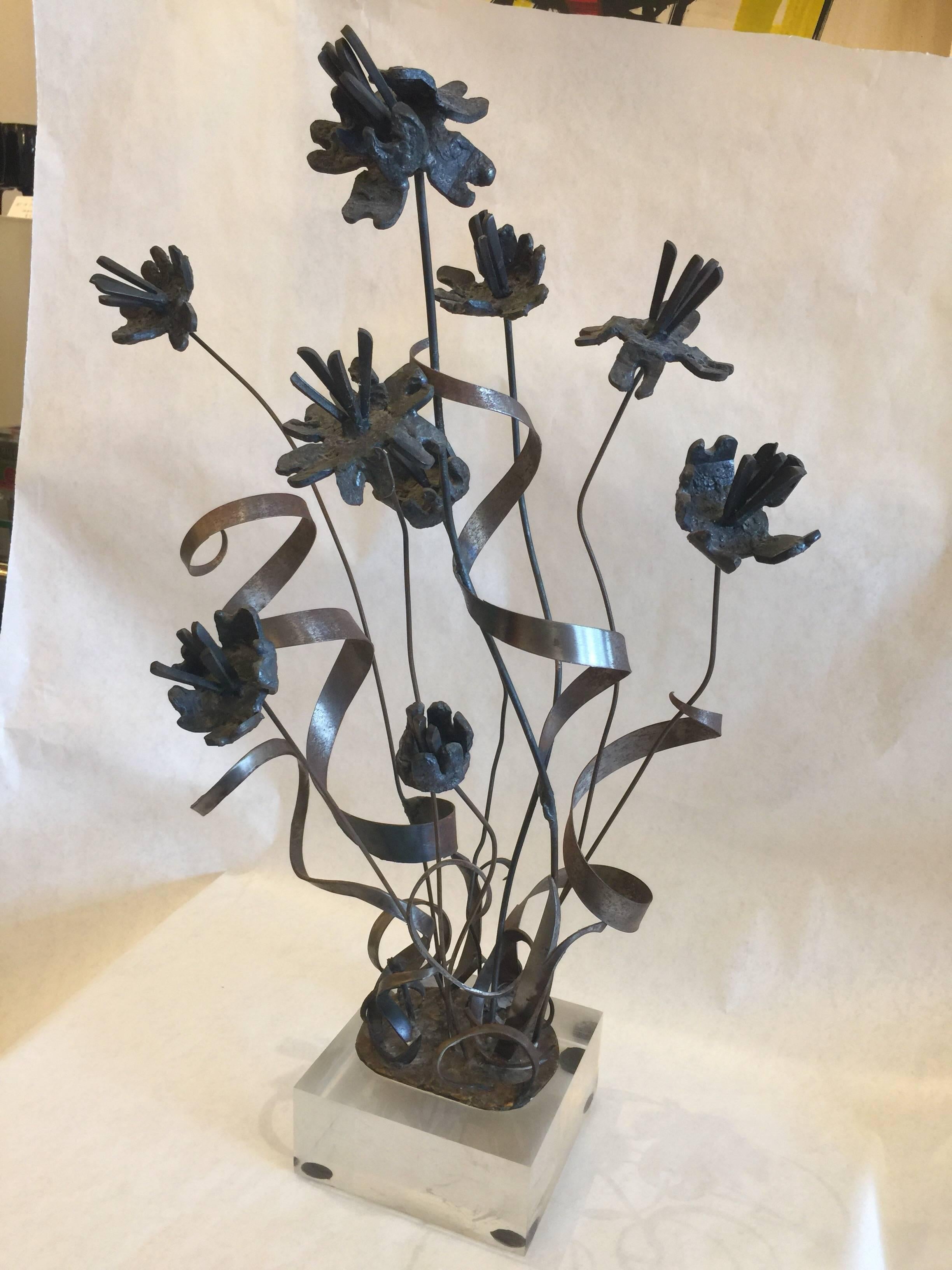 This tall vintage brutal iron floral arrangement on a Lucite base is reminiscent of the well hand crafted pieces from Paul Evans. The flowers are highly detailed, see additional images.