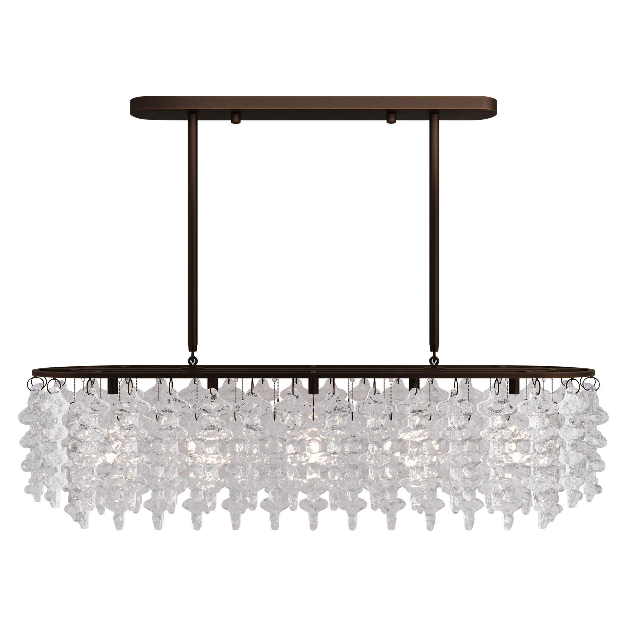 Tiers of organic Venetian glass forms, modeled after a brutalist sculpture, hang heavy yet light as air – like icicles melted in winter sun then frozen once more. Each BRUTALE glass piece on this chandelier, cast in quartz sand, glows with a fine