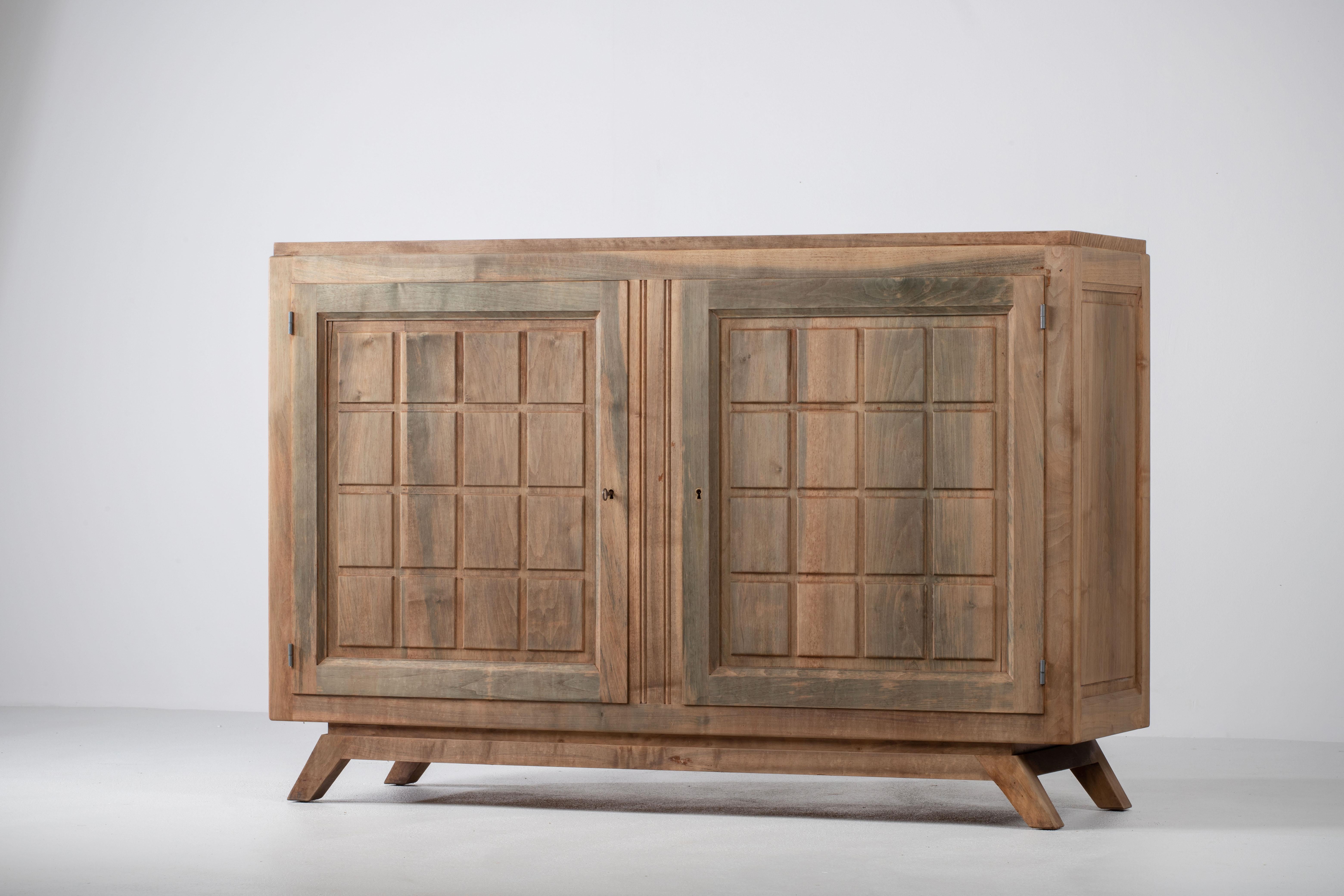 Diese französische Kredenz ist eine Komposition von stoischer Eleganz und offenbart eine Sprache der skulpturalen Zurückhaltung und des architektonischen Rhythmus. Das in massiver Eiche gerahmte Werk besticht nicht durch Ornamente, sondern durch die