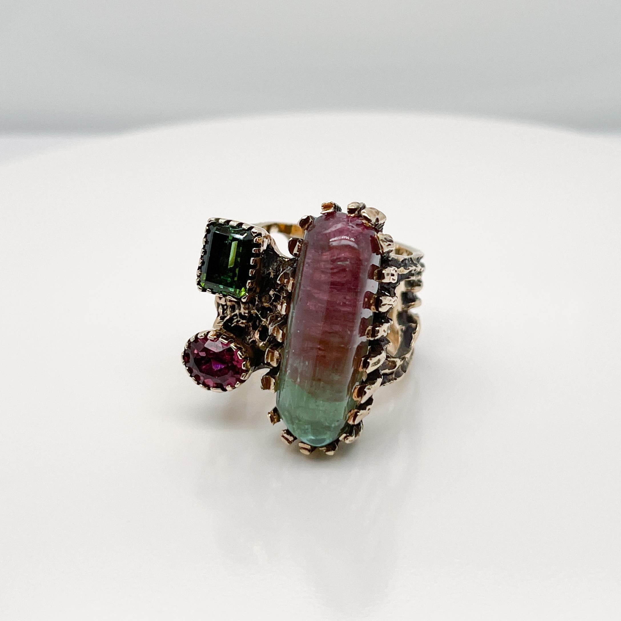 A very fine gold and tourmaline cocktail ring.

With an elongated watermelon tourmaline, a rectangular green tourmaline and an oval pink tourmaline prong set in 14k gold. 

Simply a gorgeous Brutalist cocktail ring!

Date:
20th Century

Overall