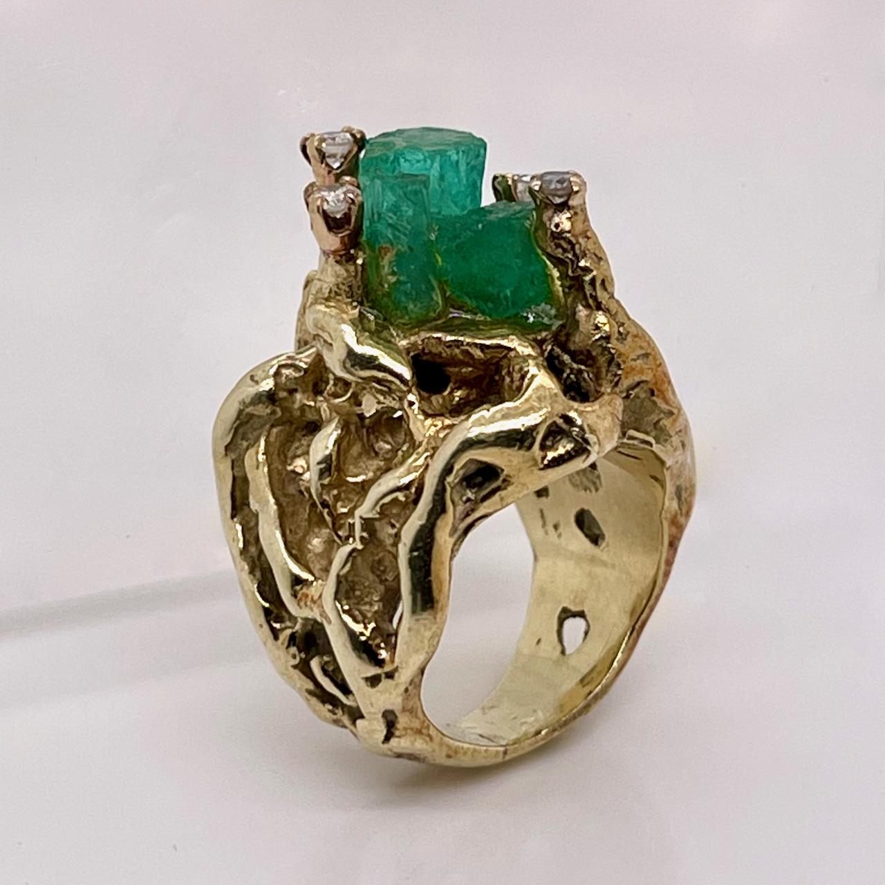 A very fine brutalist 14k gold, Chatham emerald and diamond cocktail ring.

With large raw Chatham emeralds that are center set and flanked by round brilliant prong set diamonds. 

The base and shank are cast in an organic brutalist manner.

Simply