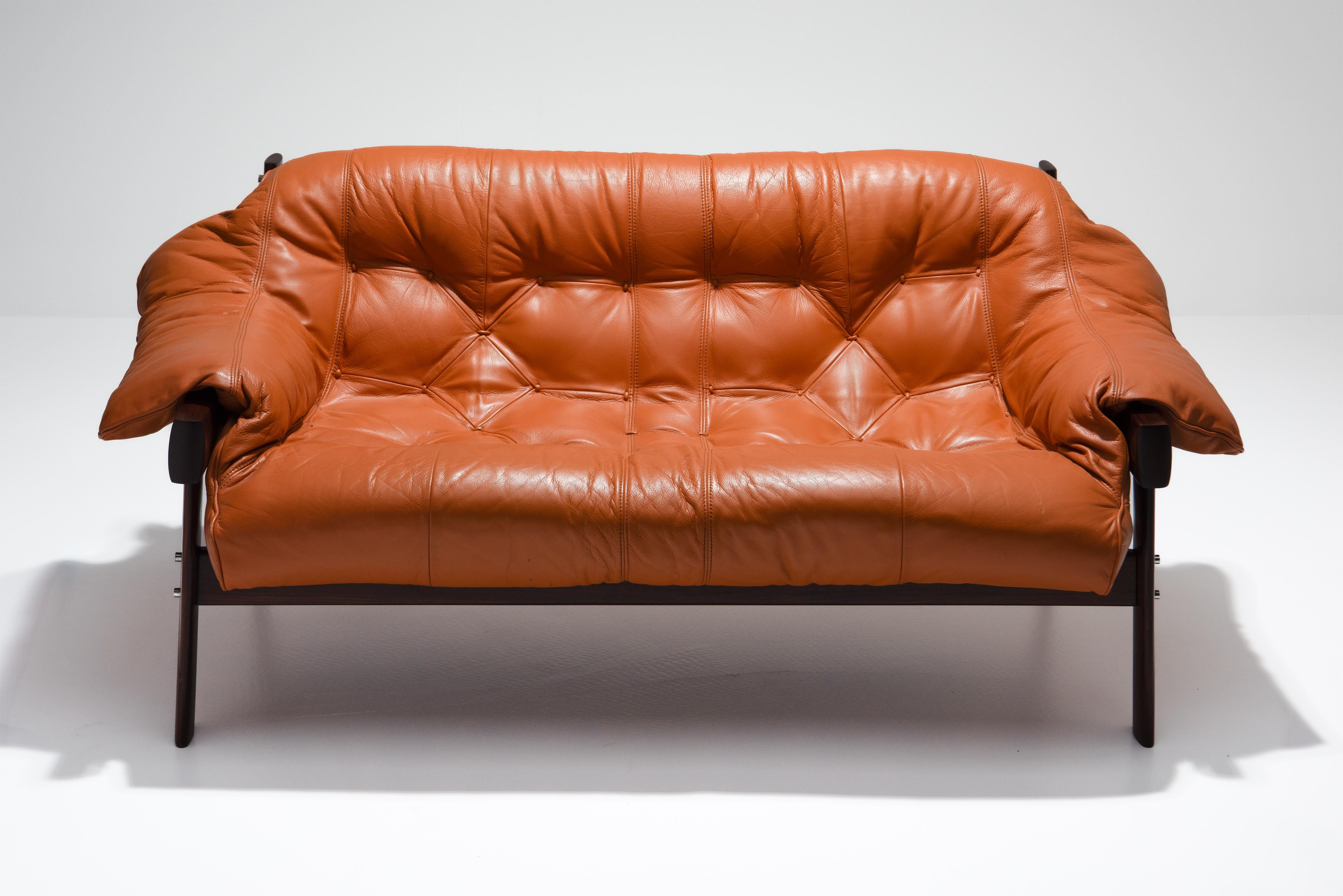 MP-41 two-seater sofa in orange/brown leather andsolid walnut frame, designed by Percival Lafer in 1970 for MP Lafer, Brazil.
The sofa was reupholstered several years ago by a professional upholsterer. The saddle leather straps that hold the