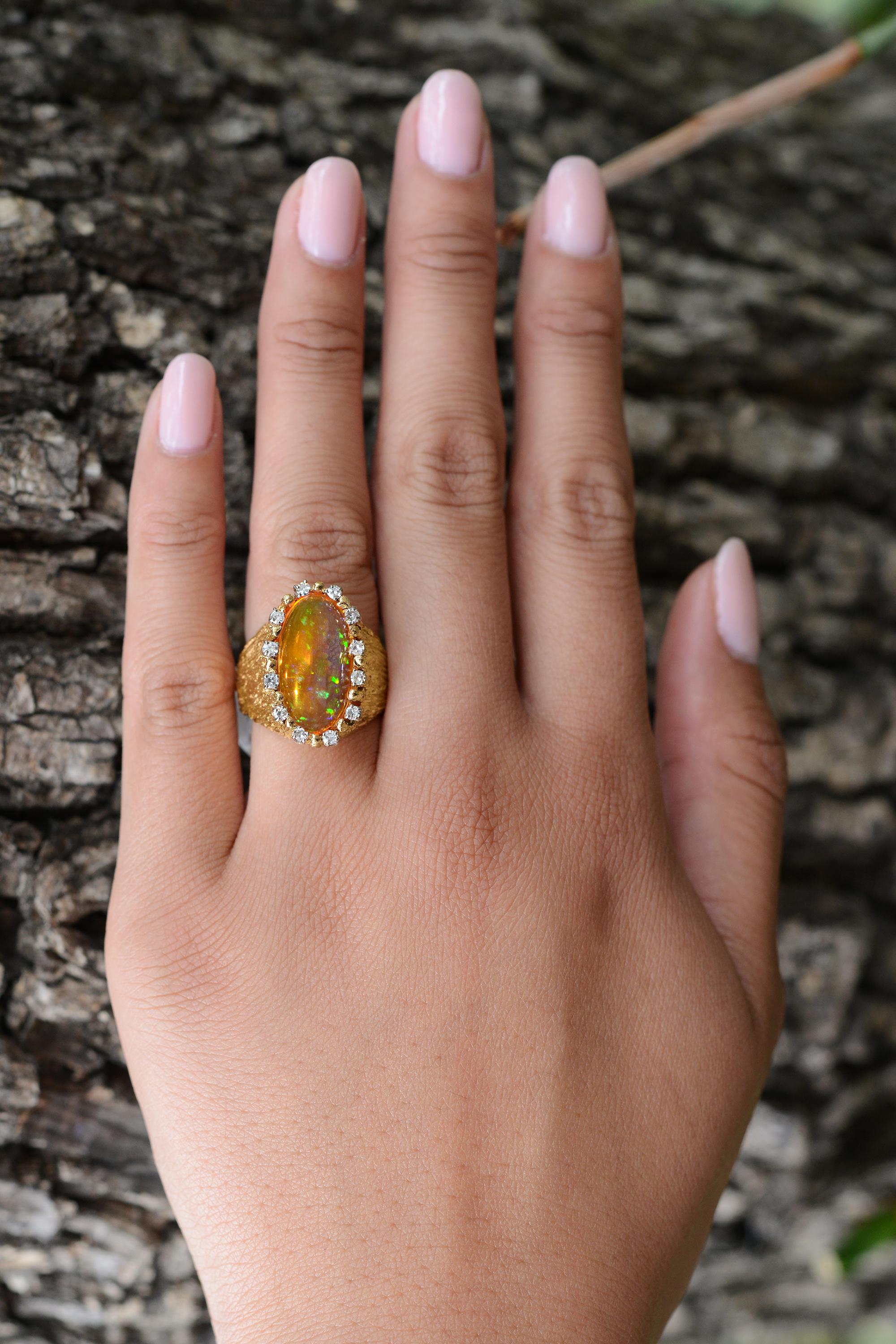 This vintage ring is from the private estate collection of iconic actor Robert Mitchum, dating back to the 1960s. Made with 18 karat yellow gold, the cocktail ring features an impressive 5.29 carat Mexican fire opal. A halo of sparkling round