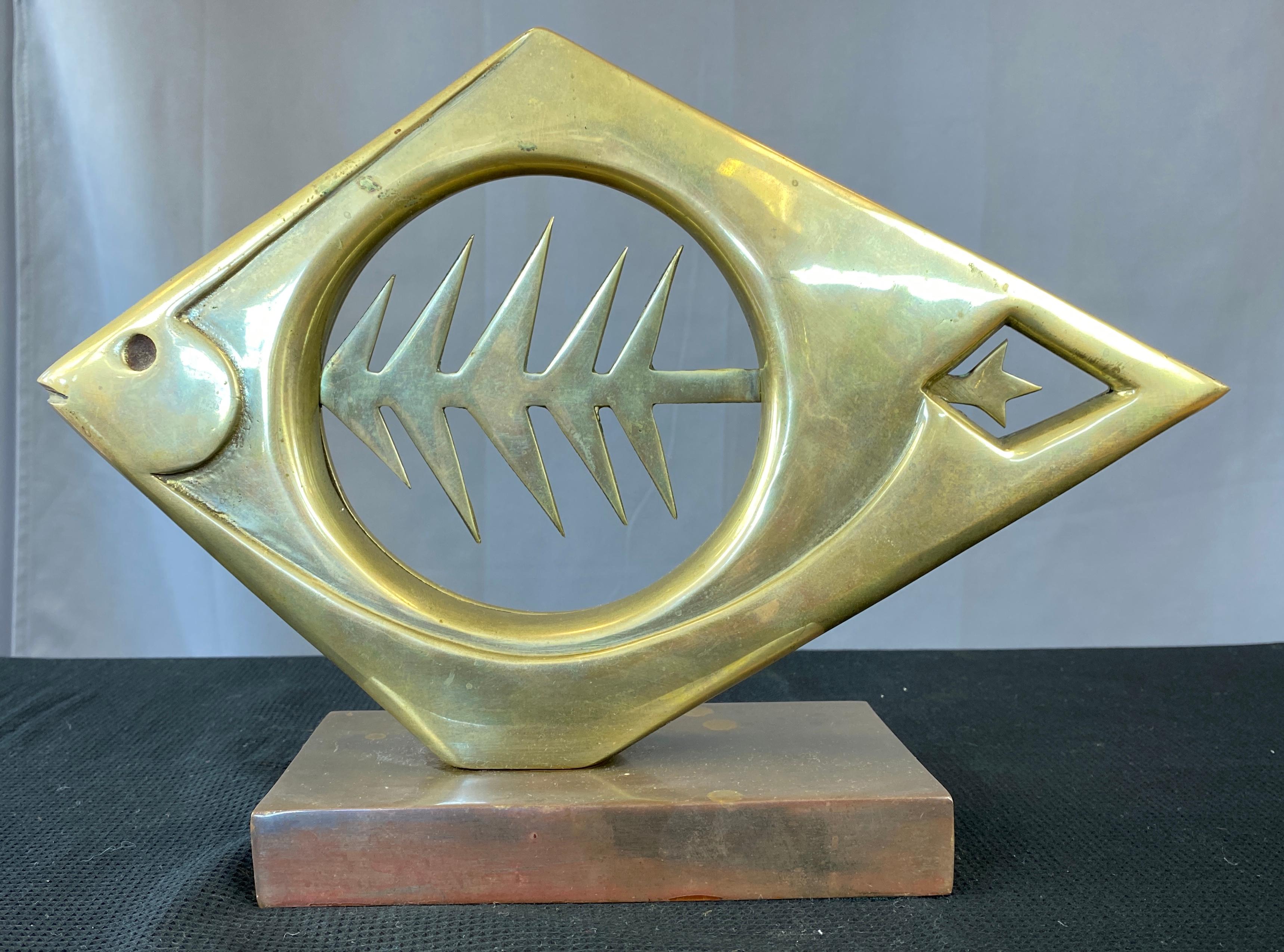 Brutalist abstract brass fish by Dolbi Cashier, circa 1980s. Dolbi Cashier was trade name of gallery house.
It sit's on a hollow weighted brass base, fish has a round cutout to show it's jagged spine.

Fish measurements are 14.25in x 2.74 x 8.88