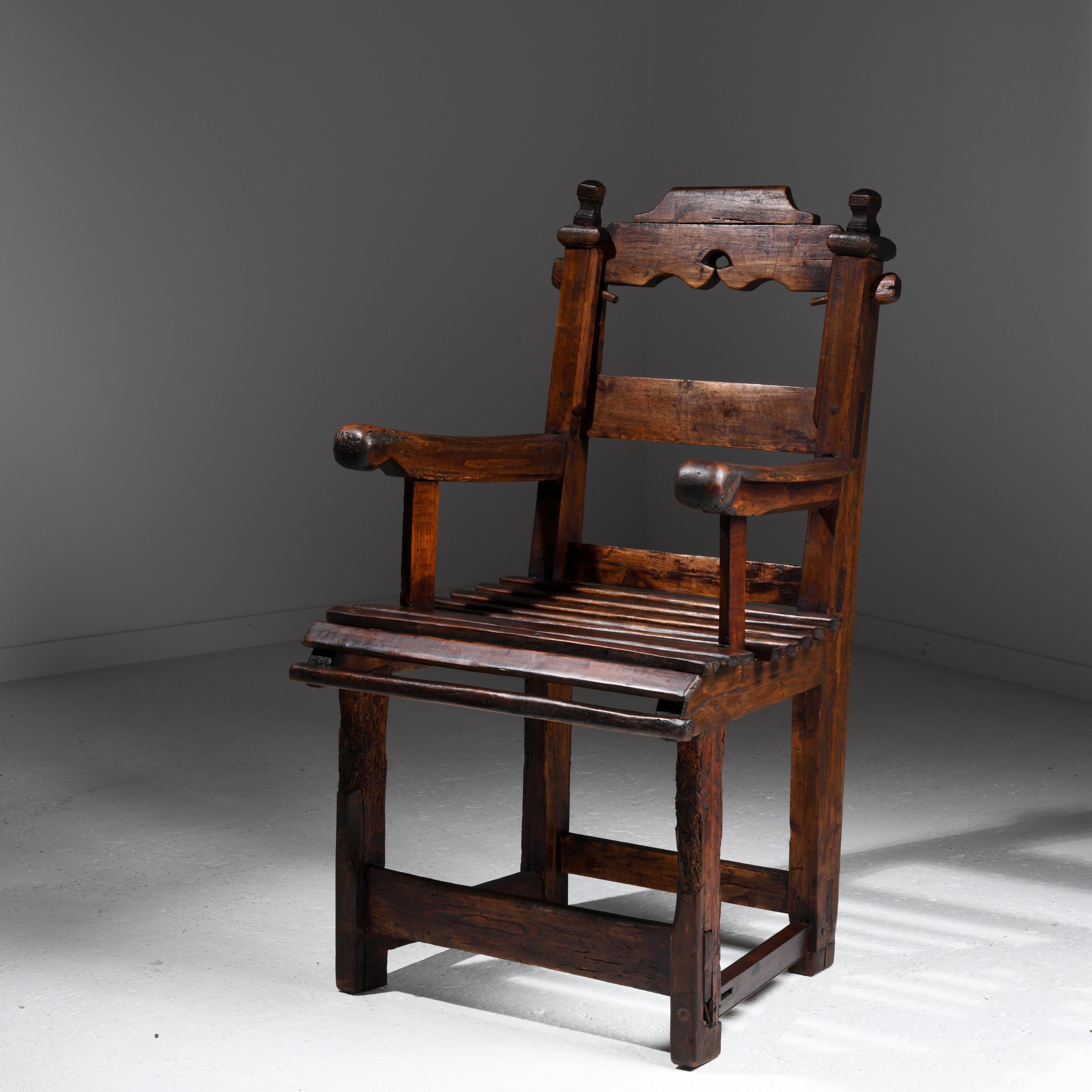 Brutalist armchair in stained wood, a popular work of art from the first part of the 20th century. Stained and waxed softwood. A particular feature is the top of the backrest that can slide along the uprights, the purpose of which I don't know? This