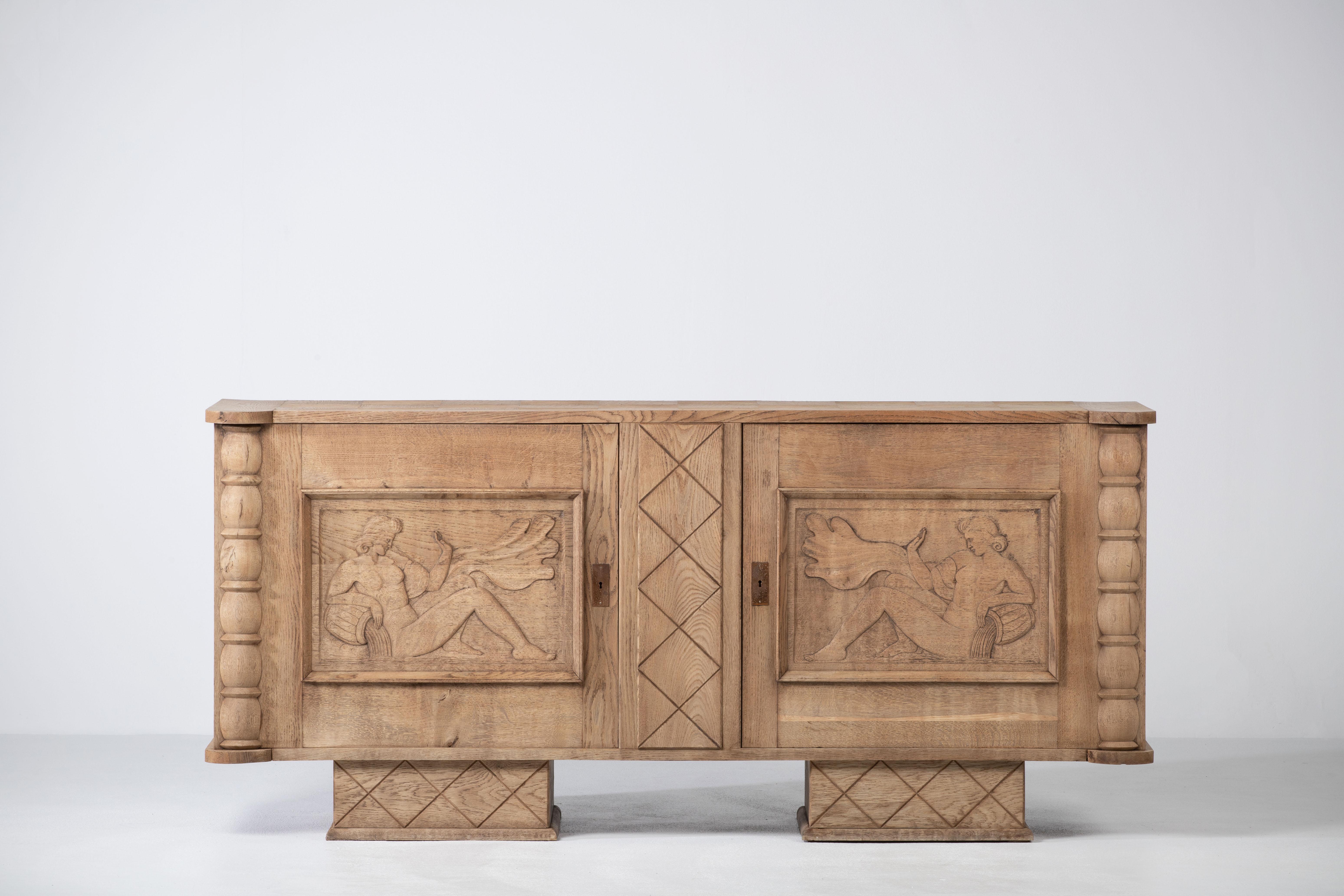 Large Art Deco Brutalist sideboard, 1940, French work. 

This unique piece consists of two doors with symmetrical carved panels featuring a hand-carved nymph on which opens a single compartment with a shelf.
The legs are covered with graphic