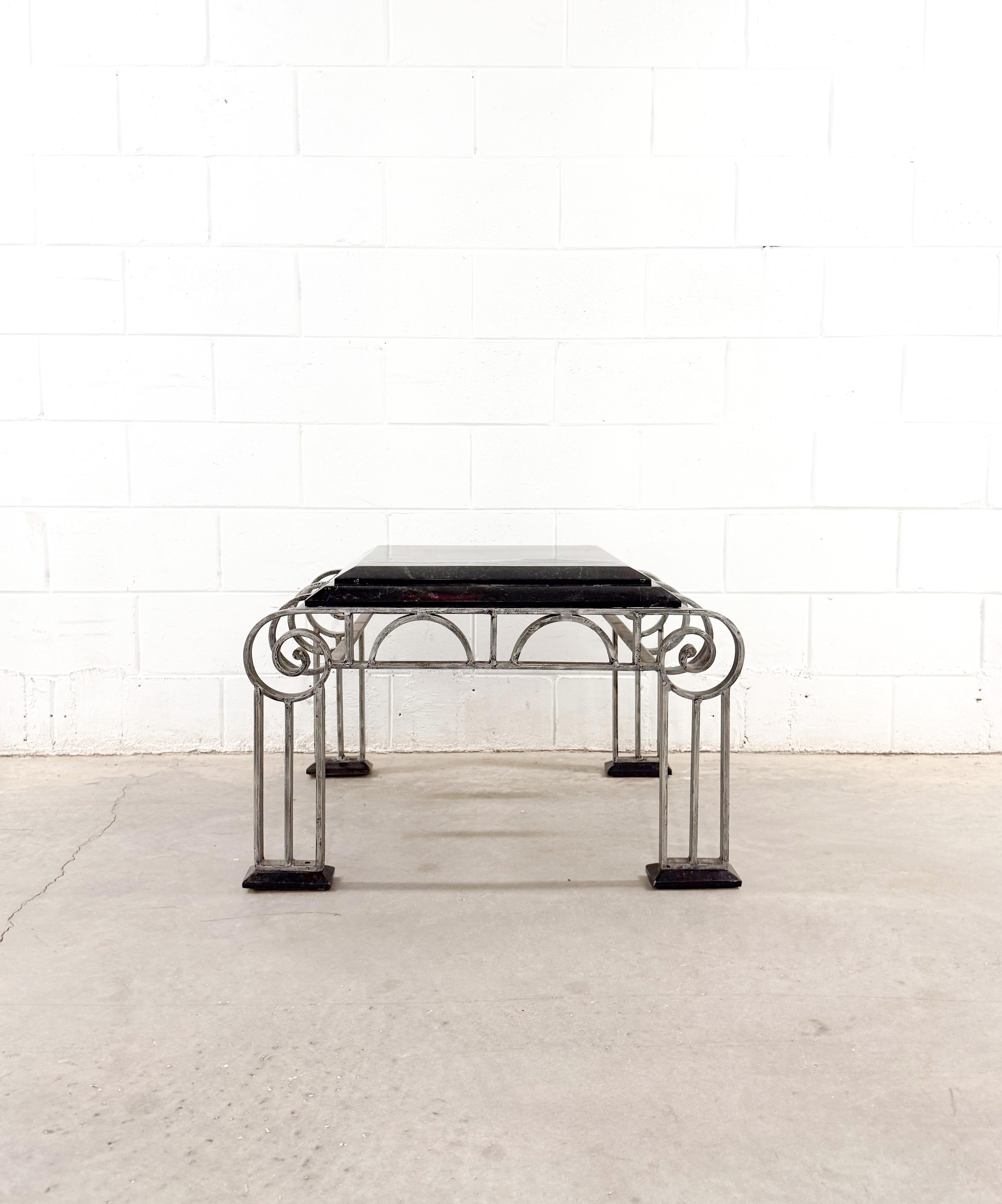 Stunning Art Deco-style coffee and side table set features a geometric arched design reminiscent of the works of Paul Kiss or Michel Zadounaïsky. Crafted from heavy-gauge, hand-forged wrought iron with a beveled marble top. The wrought iron base