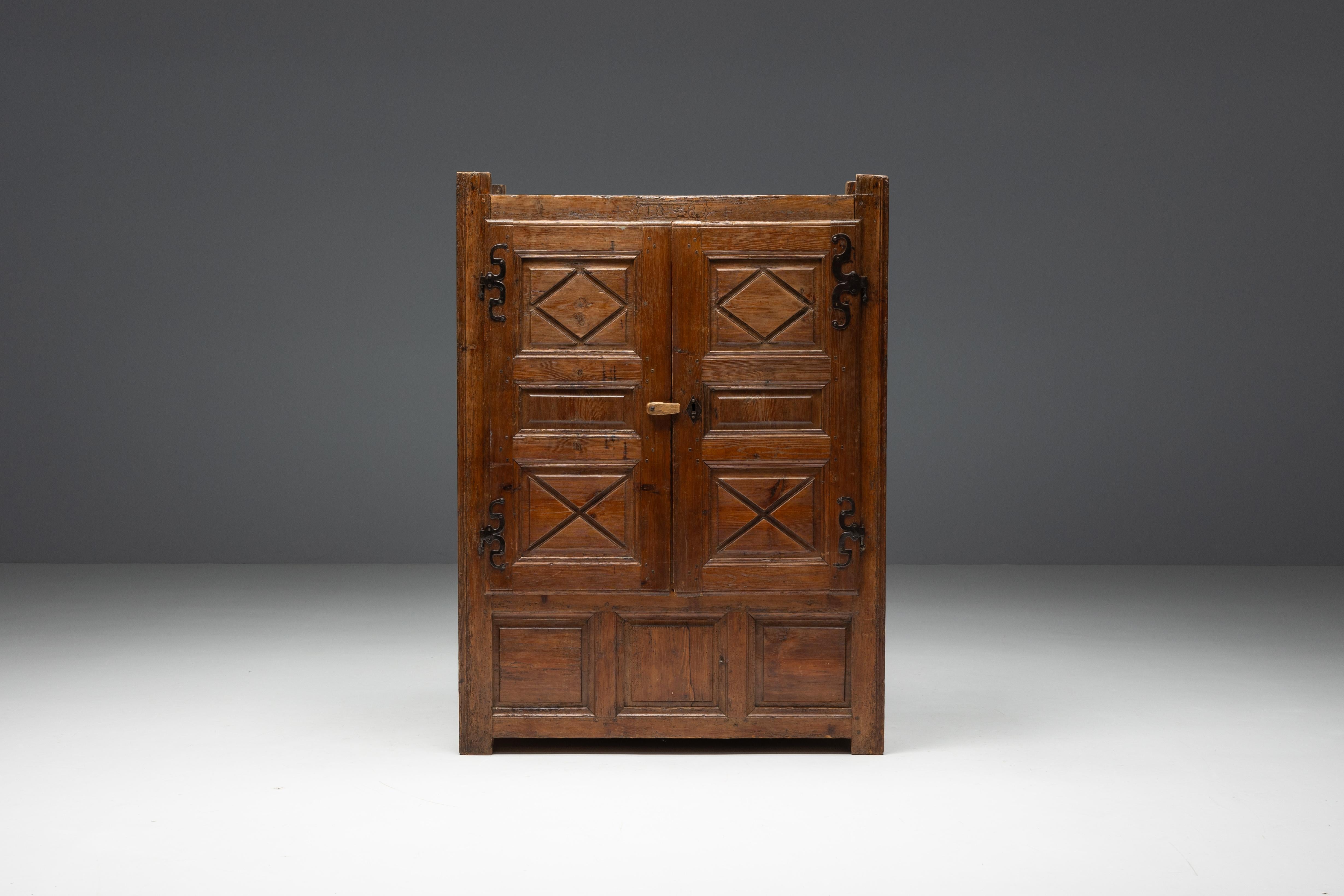 Rare armoire-coffre du XIXe siècle, en pin massif, bel exemple d'art populaire auvergnat, datant de 1848. Cette pièce originale comporte deux portes qui s'ouvrent pour laisser apparaître des étagères, ainsi que deux tiroirs, dont l'un est divisé en