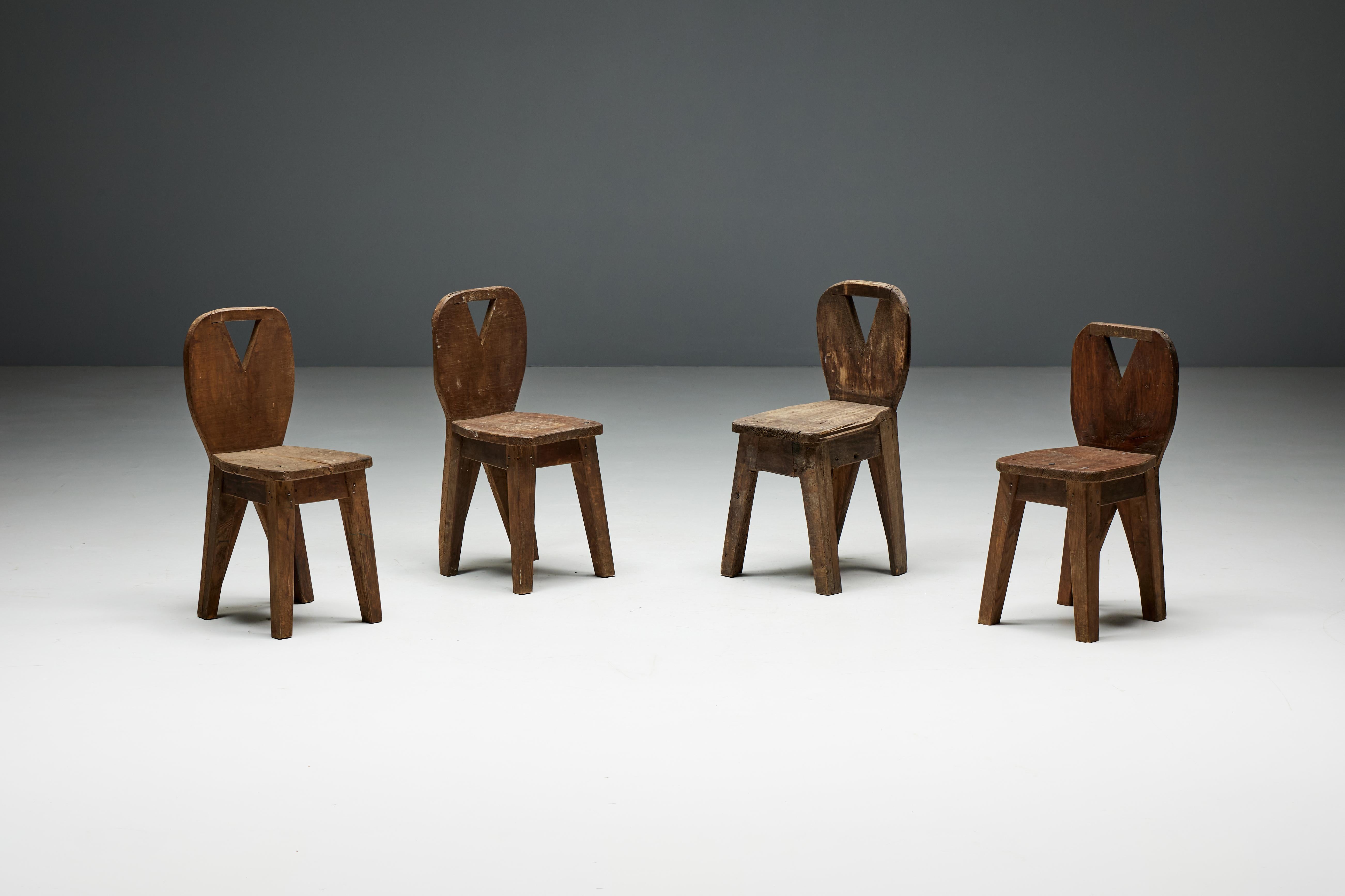 Set of four brutalist mountain chairs, made of solid wood and steeped in the rich history of Auvergne, France, in the 1950s. The sturdy construction of these chairs attests not only to their durability but also to the artisanal mastery that