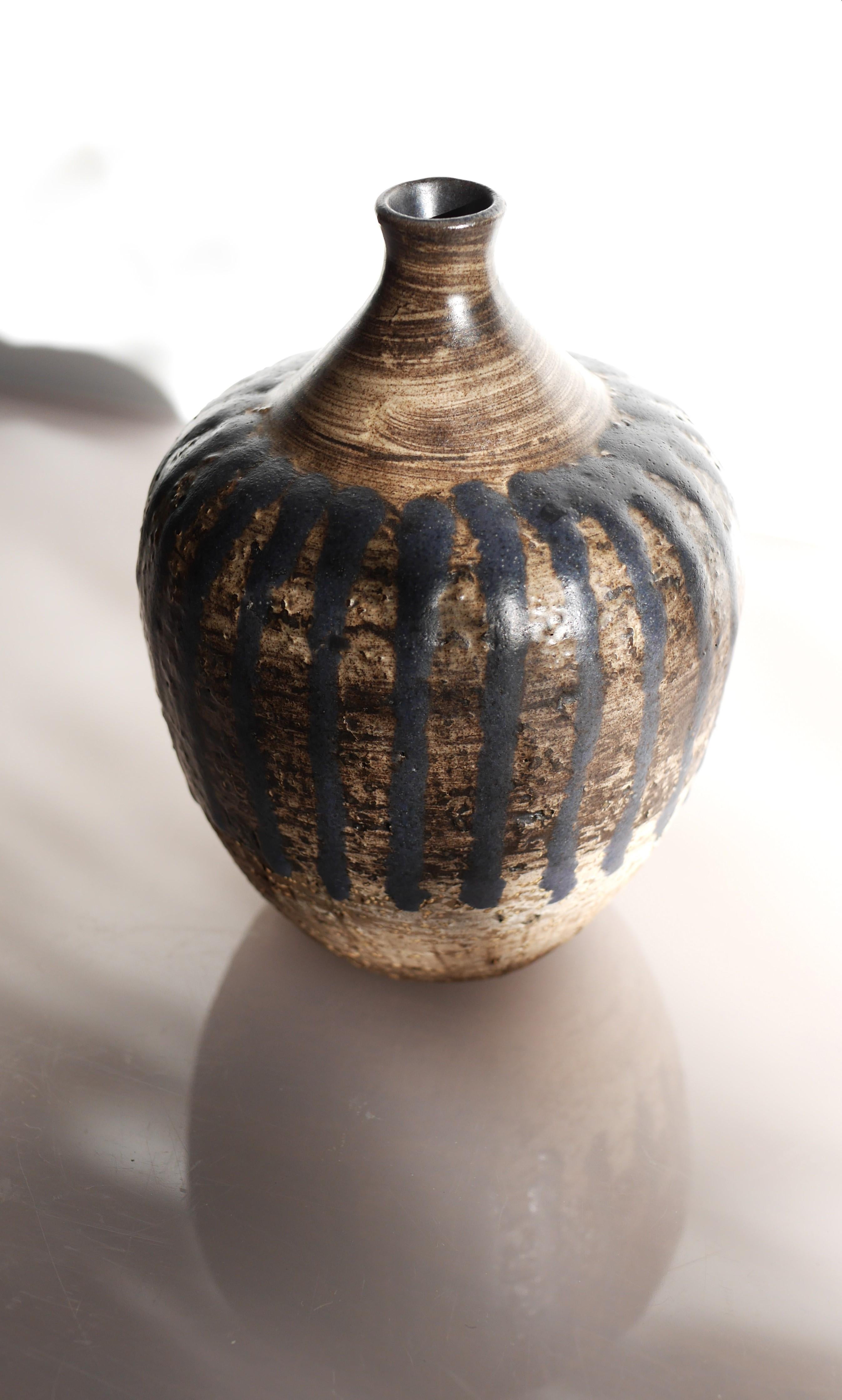 Un fantastique vase vintage en poterie d'art brutaliste fait à la main par la talentueuse et célèbre artiste Mari Simmulson pour le tout aussi célèbre Upsala Ekeby dans les années 60. La base est marron foncé et les motifs graphiques présentent des