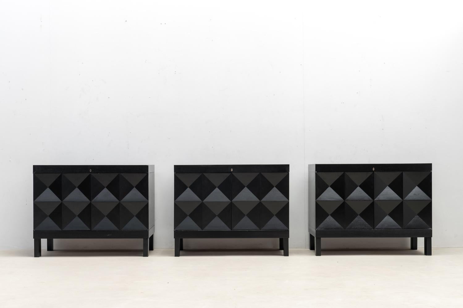 Voici un bel ensemble de cabinets graphiques créés en Belgique à la fin des années 60. Ces armoires en chêne teinté noir sont dotées de portes décorées d'un motif géométrique, ce qui ajoute de la profondeur au design.

A l'intérieur, de nombreux
