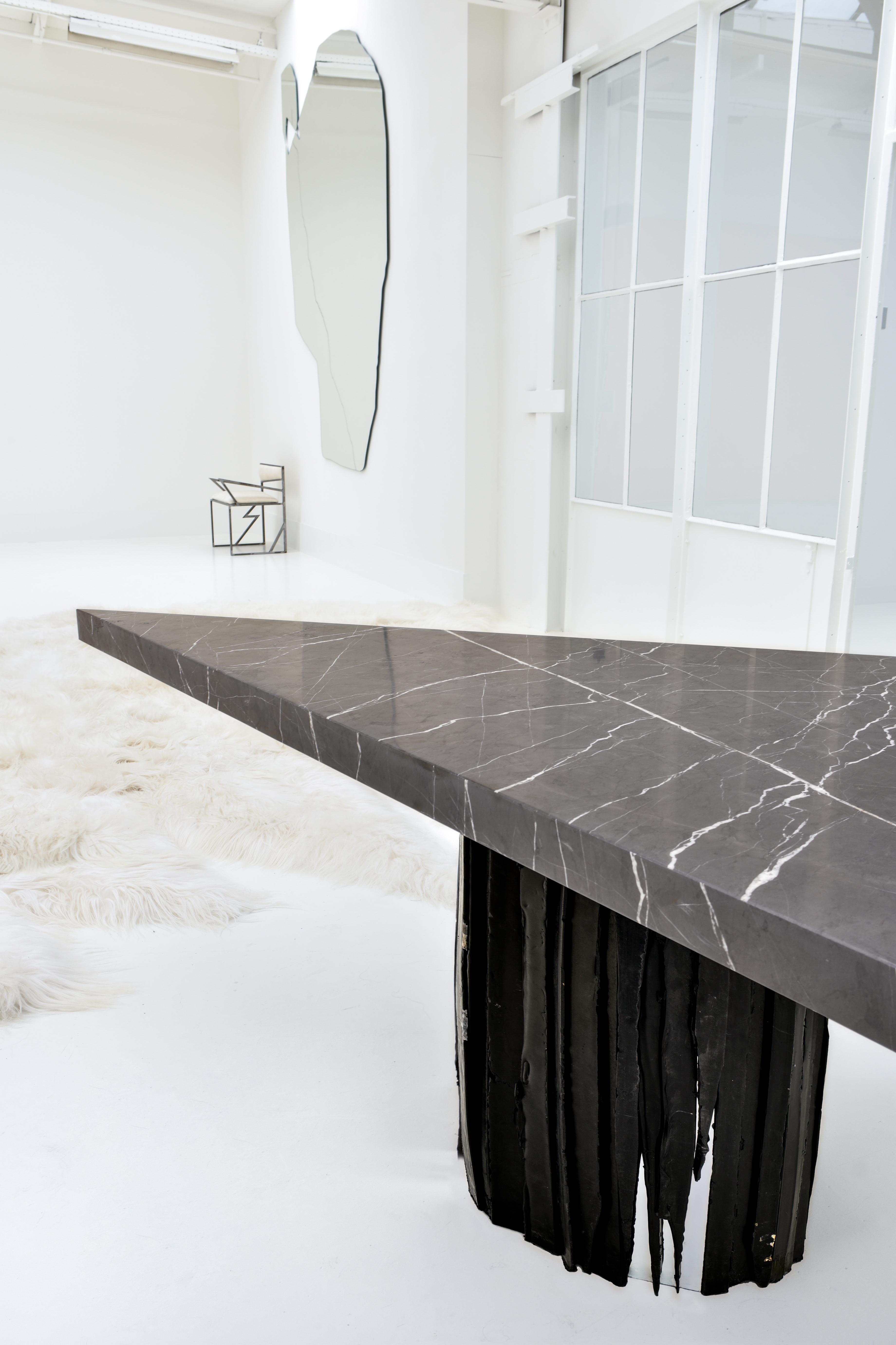 This collectible design triangular desk or center piece table, made of luxurious black marble with modern waste materials, is designed by female artist / designer Roos Schneijderberg.

This exceptional, brutalist, almost 'primitive and savage' piece