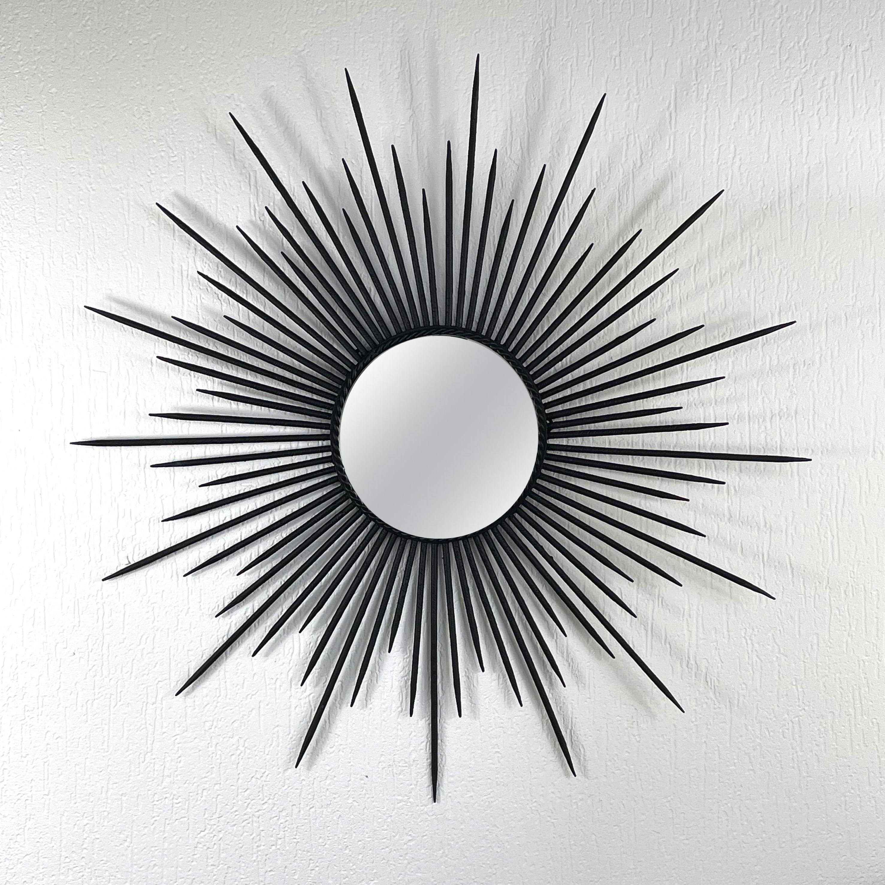 This unusual midcentury brutalist sunburst wall mirror was designed and manufactured in France in the 1950s. It features a blackened wrought iron frame and mirror glass.

Total diameter is 29.2