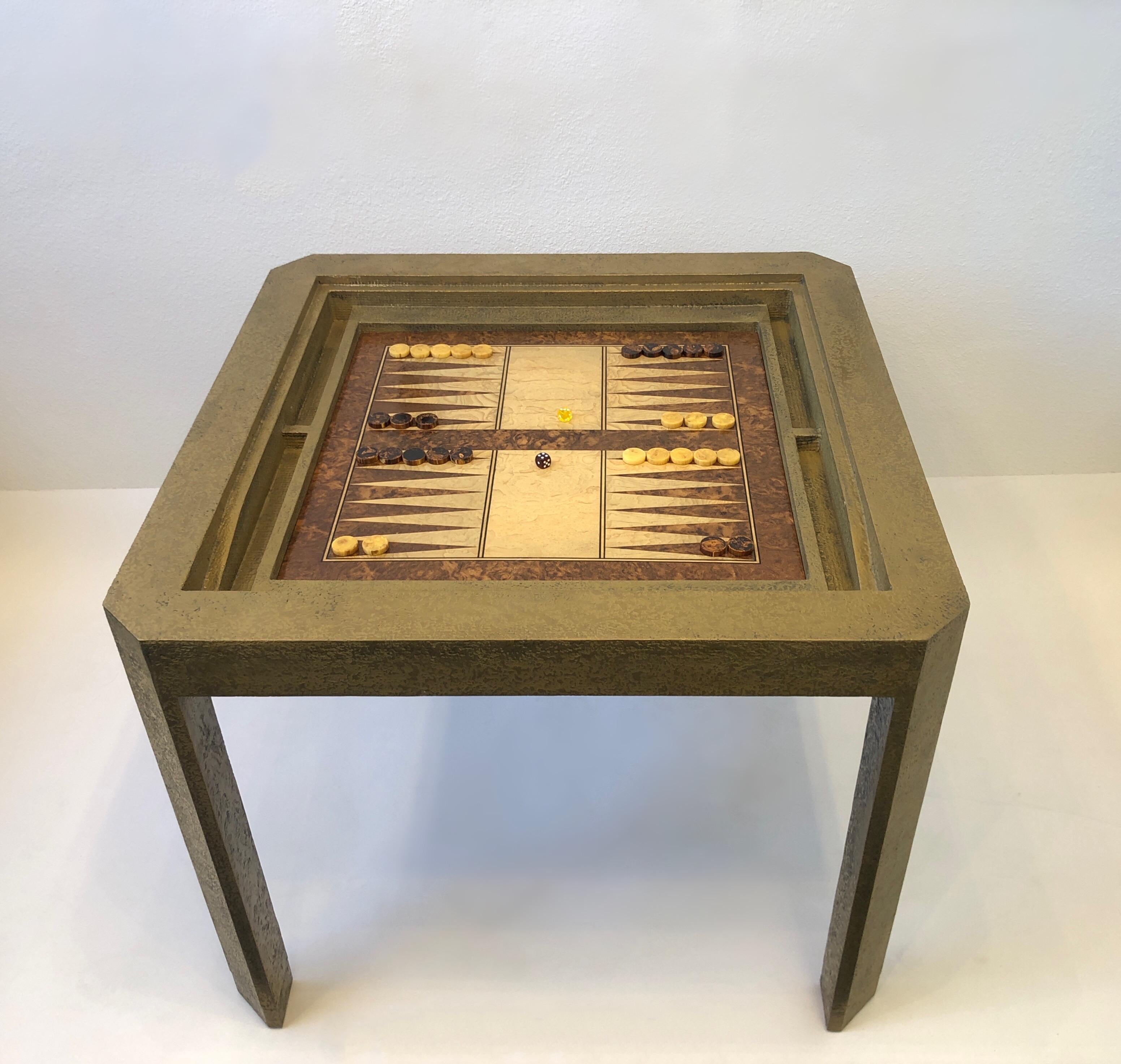Glamorous Brutalist brass and burlwood game table by Steve Chase. 
Constructed of wood covered with aged brass texture finish.
The game board is lite and dark burlwood with one side for backgammon and other side for chess. 
It also has a cover, so