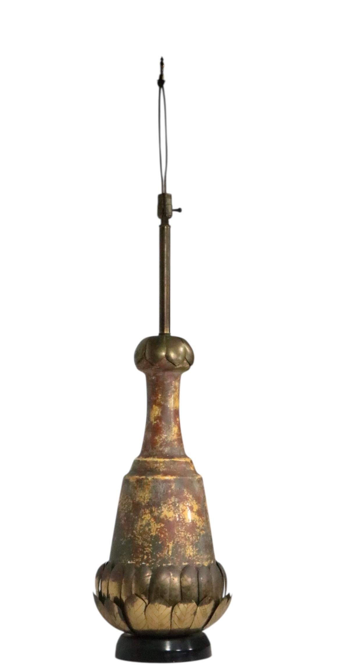 Exceptional Brutalist style table lamp, in good, original, clean and working condition. This unusual lamp features a wood plinth base, the lamp body has brass lotus leaves on the bottom, an earthen toned ceramic body and brass leaves at the top.