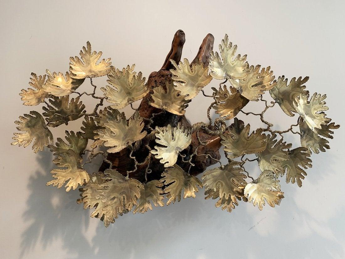 Brutalist brass and driftwood sculpture made in San Francisco California in 1981 by Rex A. Spross.

The piece is torch cut brass made to resemble maple leaves, the are attached to a twisted brass structure which in turn is attached to a large