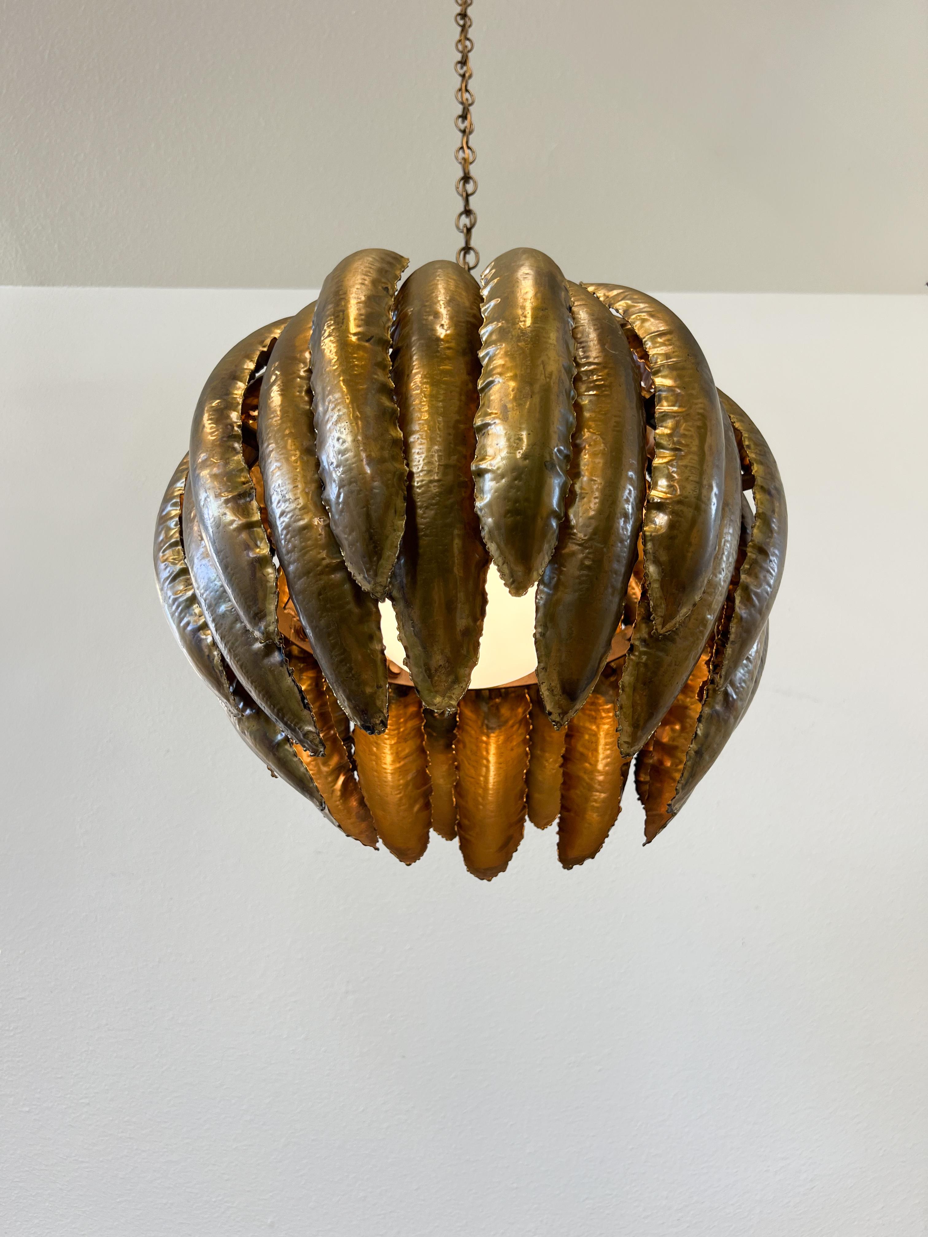 Lampada lampadario brutalista del 1970 in ottone tagliato a torcia e vetro bianco di Tom Greene & Greene.
In buone condizioni vintage originali. Presenta lievi segni di usura dovuti all'età. 
Ha una catena lunga 17 piedi, per cui può essere