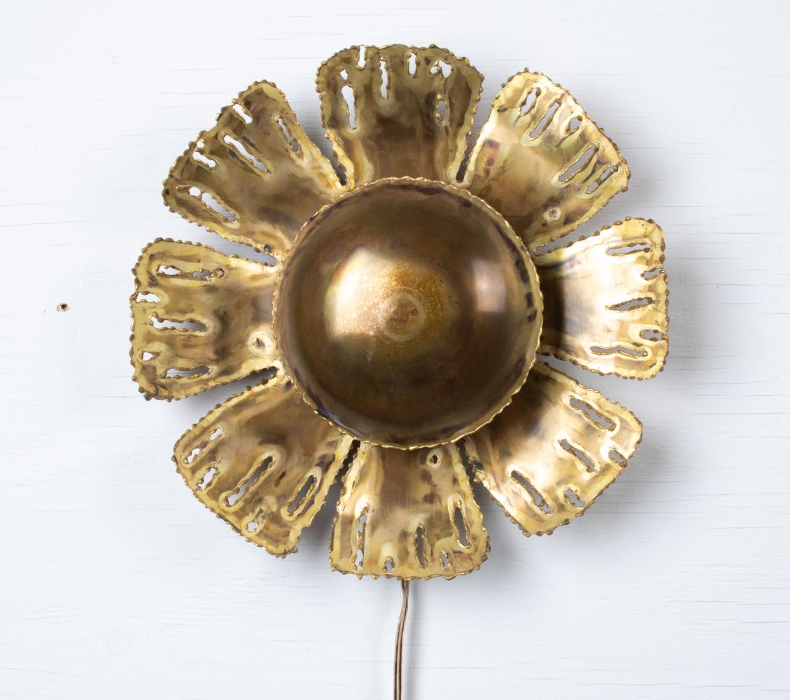 A fabulous Danish midcentury wall sconce designed by Sven Aage Holm Sørensen for Holm Sørensen and Co. in the 1960s. This whimsical Scandinavian Modern light is in a charming organic flower form crafted of acid-cut and patinated brass in the