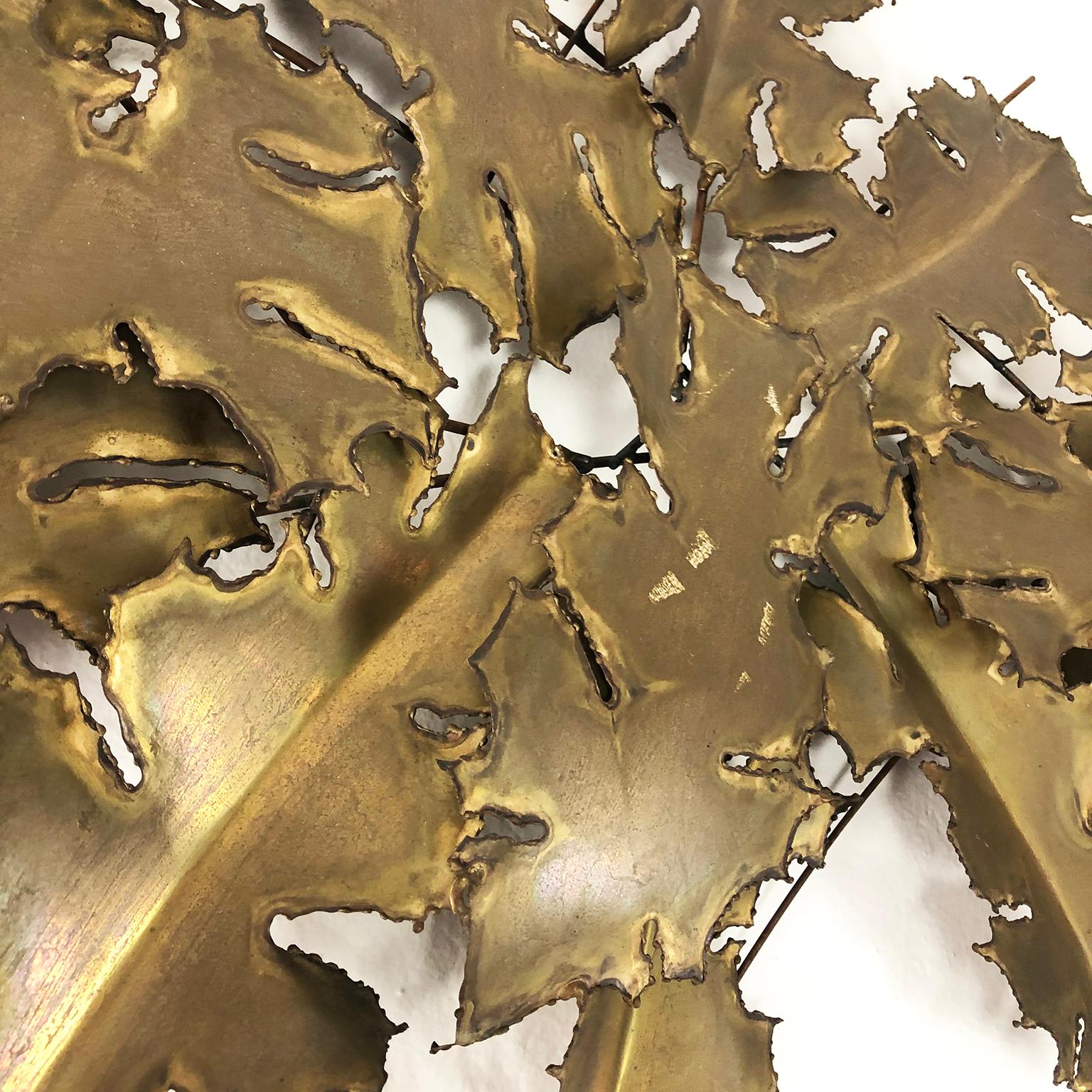 Circa 1960. We offer this Brutalist brass wall sculpture in leaves form, signed by EBANO.