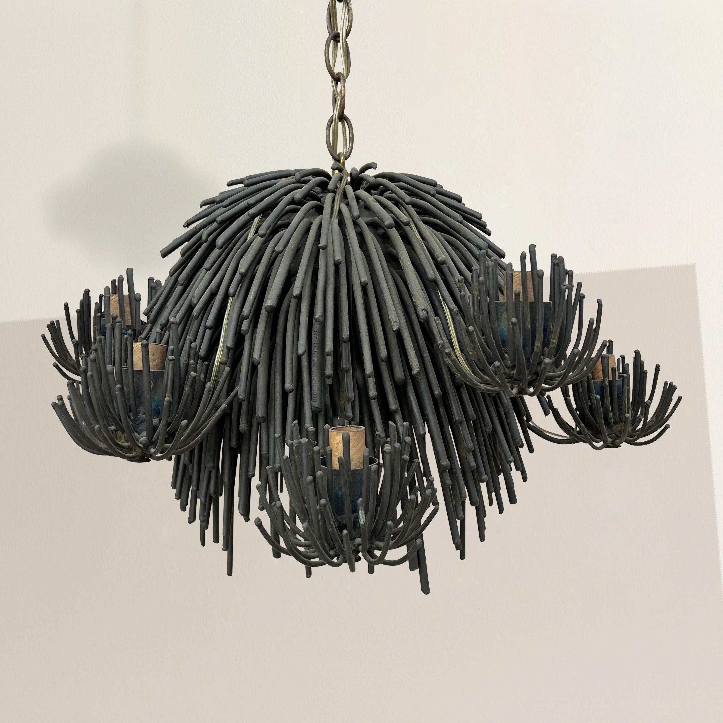 This Brutalist bronze eight-arm chandelier crafted by mid-20th century artist Belva Ball is a true testament to her innovation within the brutalist art movement. This unique masterpiece, possibly the only one of its kind, is a captivating blend of