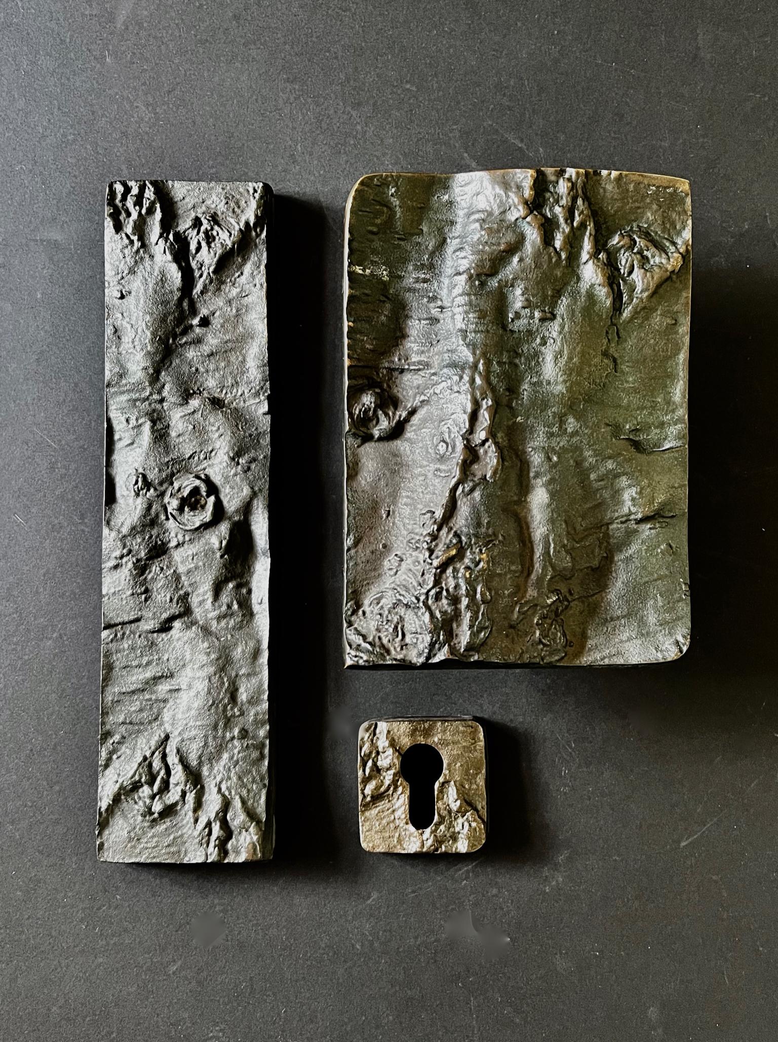 A large and impressive Brutalist bronze door handle with tree bark design, together with matching keyhole plate and letterbox cover. European, second half 20th century.

The pieces are heavily textured, with lots of movement and depth in the design.