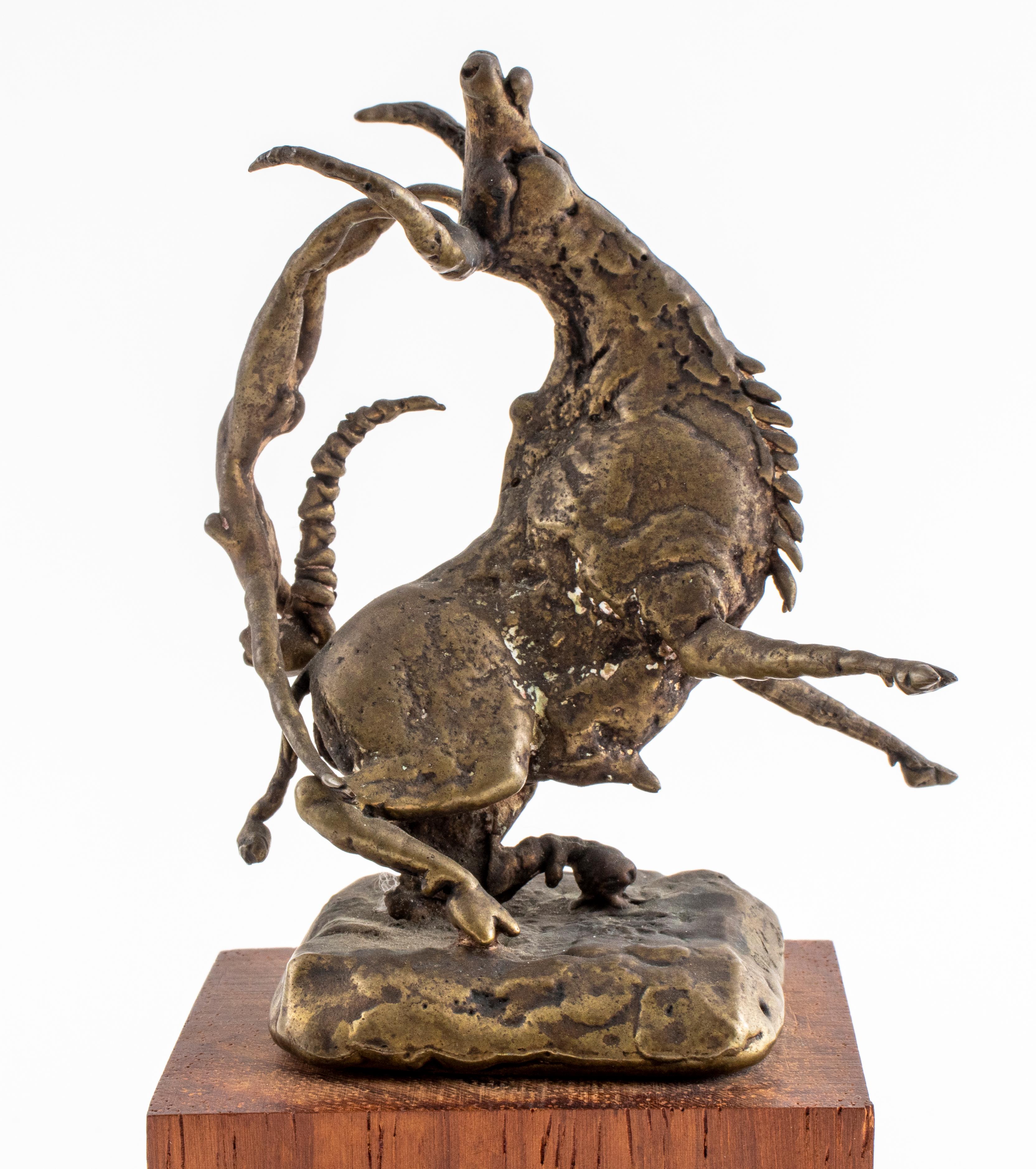 Modern Brutalist bronze sculpture of a charging longhorn or bull in motion, with a nude woman acrobat balancing on its horns, on a wooden base, incised with signature and edition number on side of bronze base.