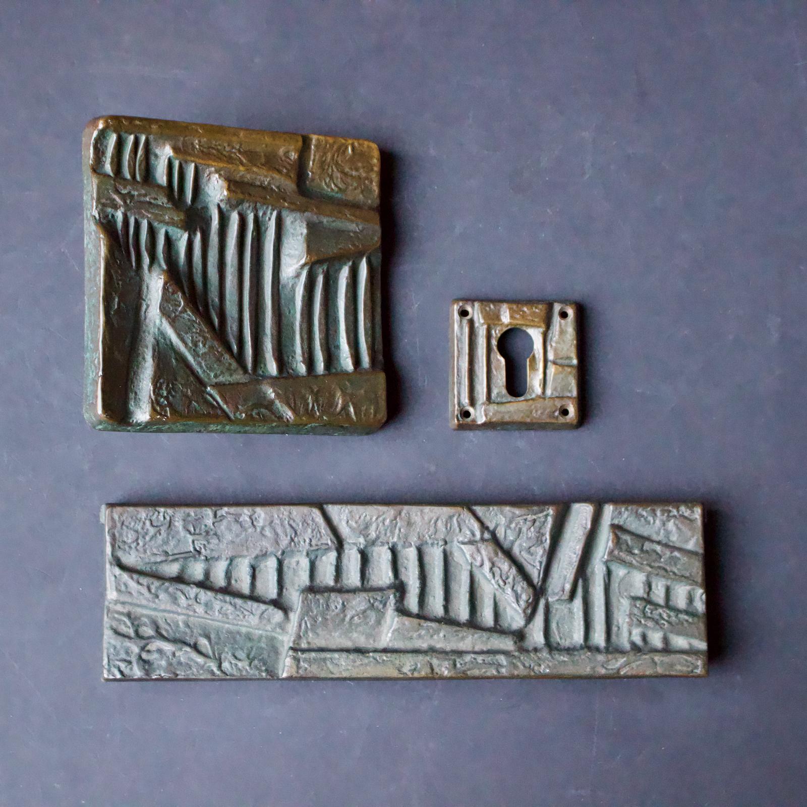 A square Brutalist bronze door handle with abstract design, together with matching letterbox cover and keyhole plate. European, second half of the 20th century - we would guess 1970s.

The items in this set have been left as found. They have lots