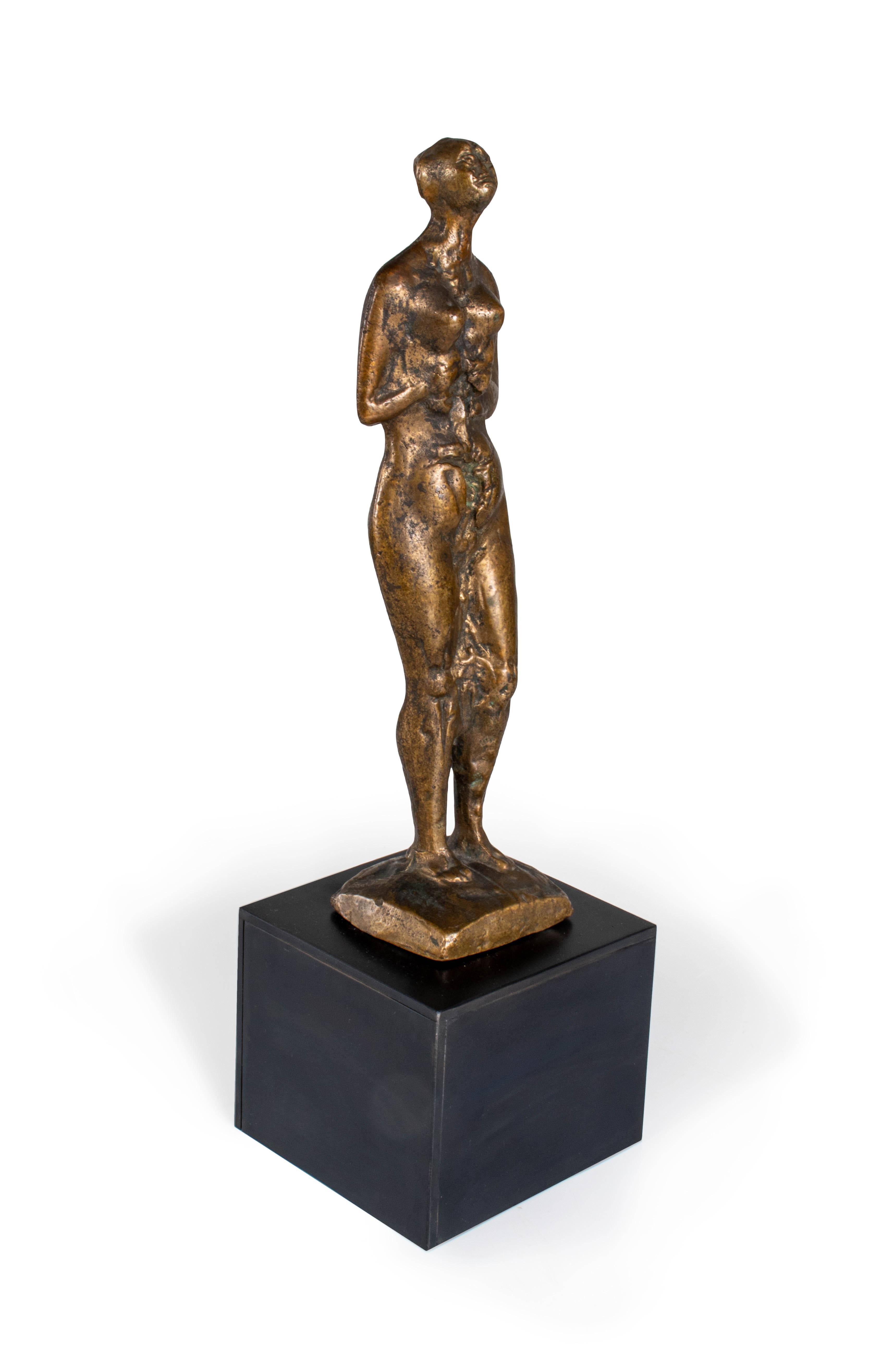 This statue is made of bronze and depicts a nude female figure. It's a beautiful piece of home decor that would complement any contemporary or vintage-inspired aesthetic. This statue is perfect for adding a touch of elegance to any home decor. The