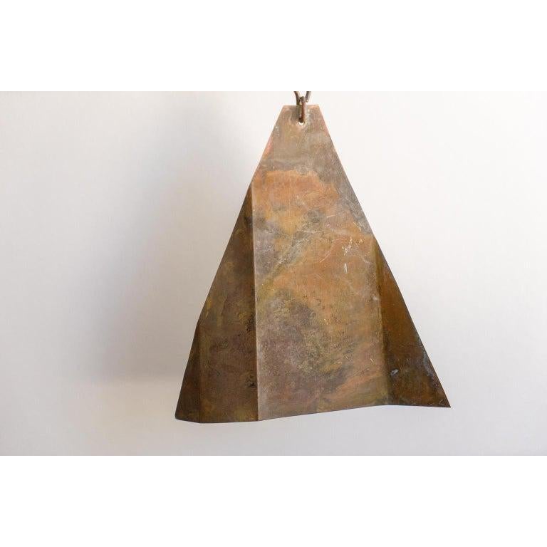 This Mid-Century Modern bronze wind chime retains its original finish and was created by the Italian-born artist Paolo Soleri. Soleri designed and created this piece in his Cosani workroom in Arizona.