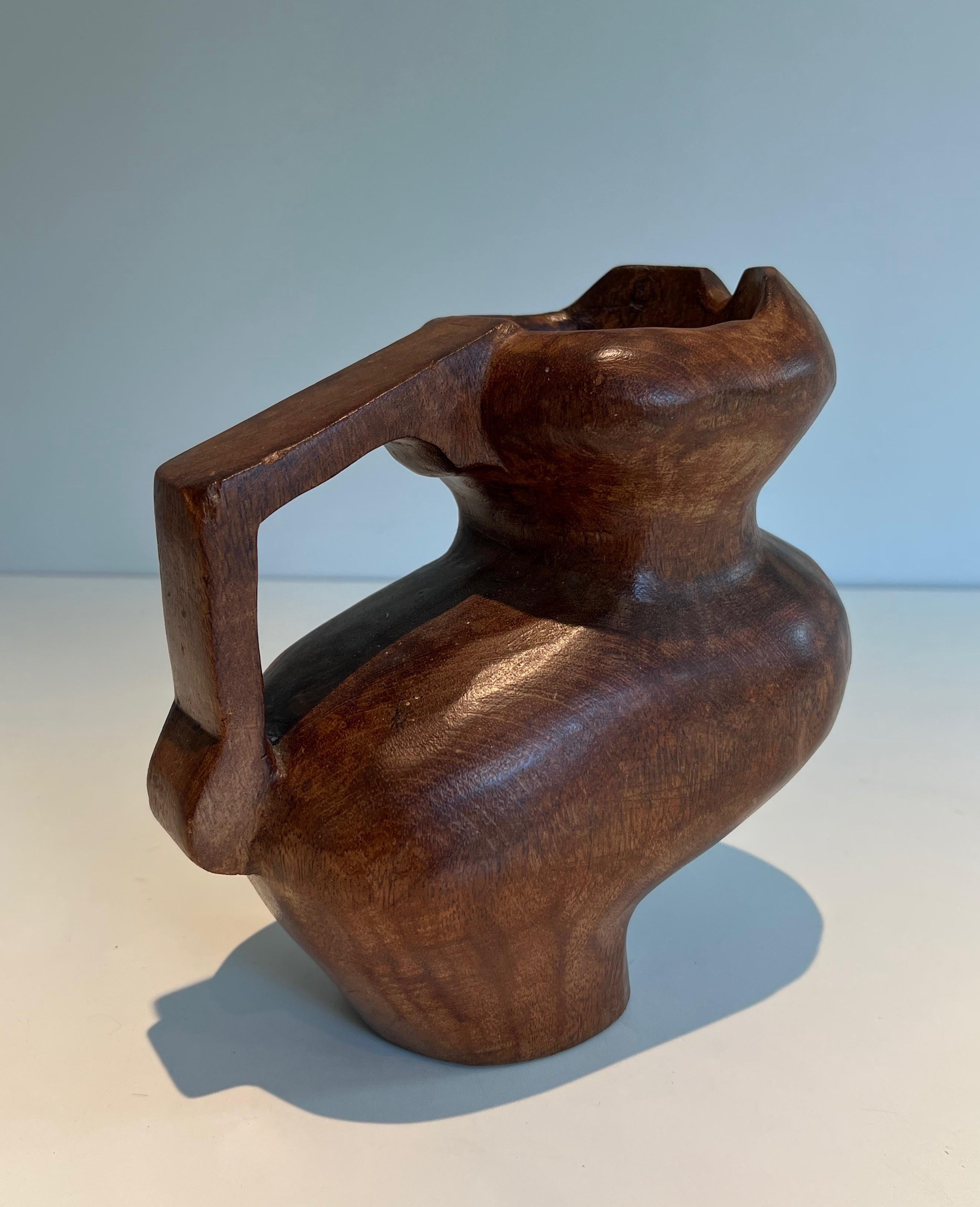 This nice and unusual brutalist pitcher is made of carved wood. This is a French work in the style of Alexandre Noll. Circa 1950