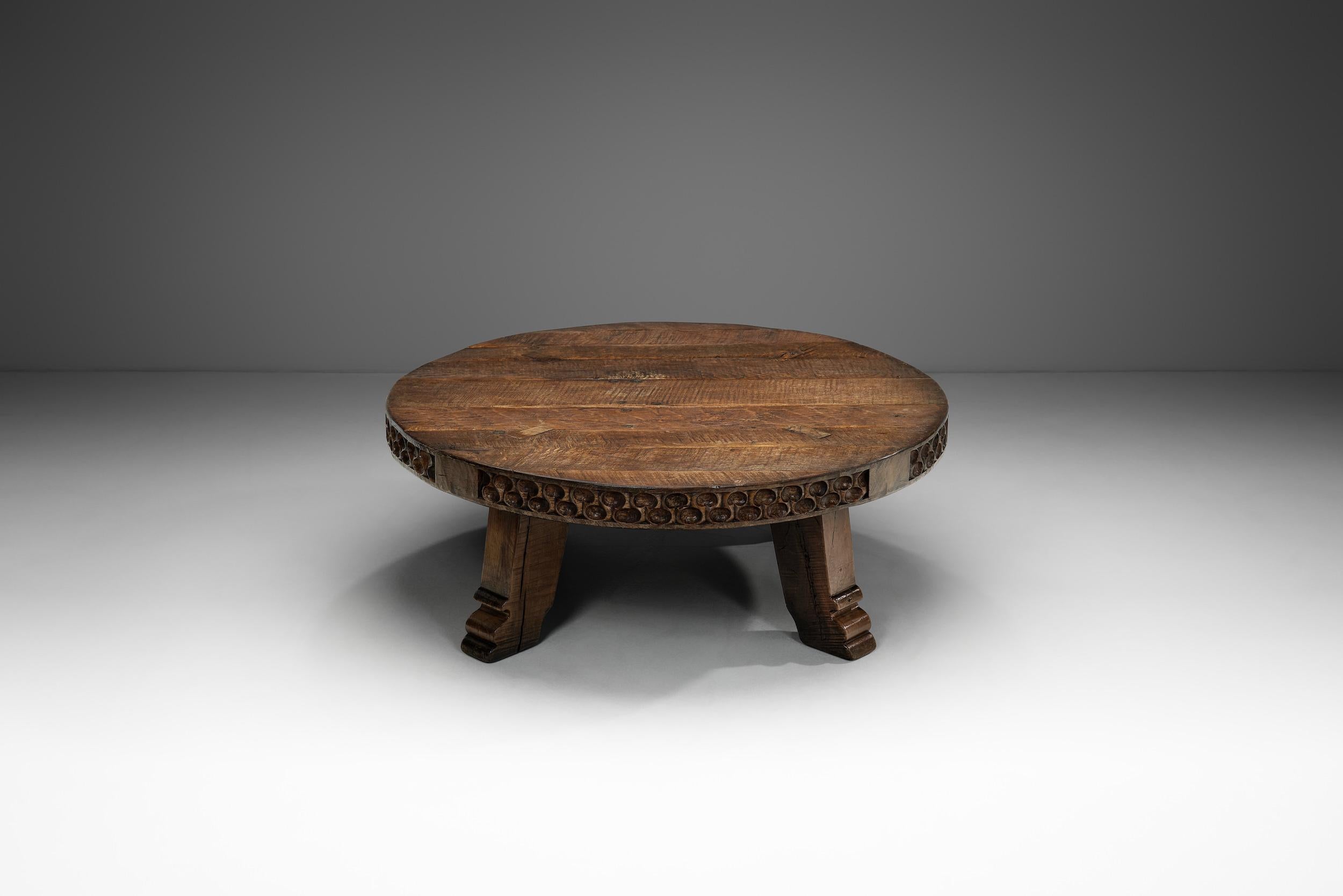 With a robust form this coffee table is the embodiment of 20th century brutalist design. It is somber, giving importance to eerie organic and rugged shapes in dark, earthy tones. The carvings, imperfections of the wood and the simple, rough design