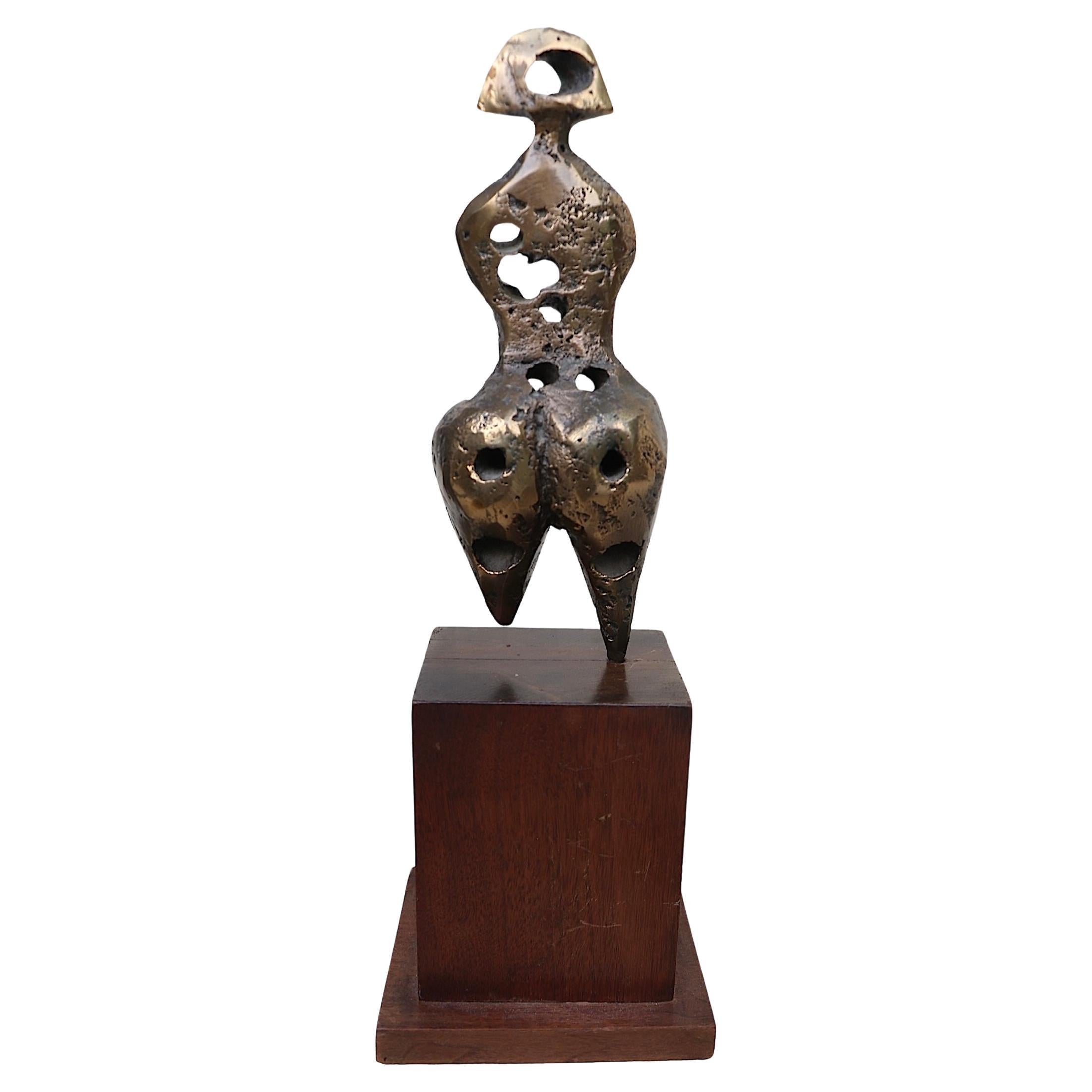 Period 1970's Brutalist sculpture depicting a stylized  female figure executed in cast brass, mounted on a stepped walnut plinth base. Well crafted work, in excellent original condition, done in the style of Henry Moore, this example is unsigned. 
