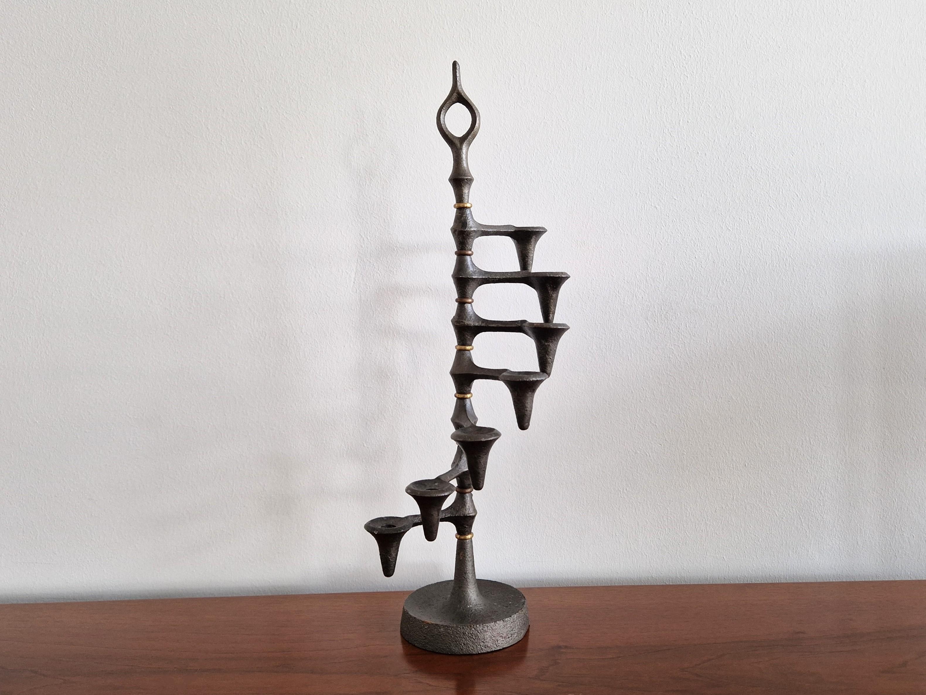 This iconic candelabra or candle holder was designed by Jens Quistgaard in the 1960s. A brutalist design that is made out of cast iron and brass. It has 7 adjustable arms that can rotate in any position.  We have 3 of these candelabra's available