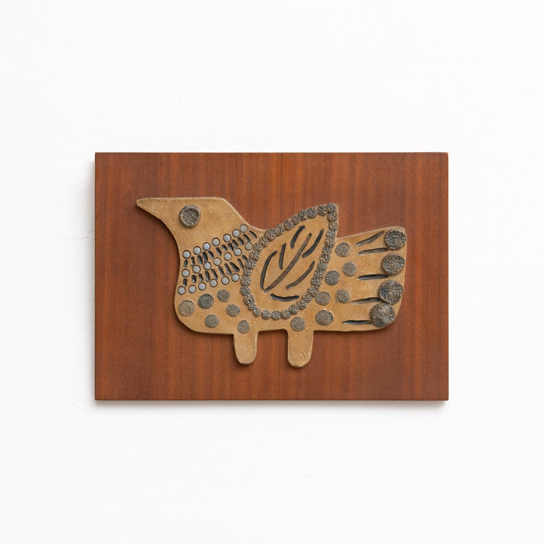 Ceramic hand painted artwork of a bird on a wooden wall board, circa 1960.
Framed.

In original condition, with minor wear consistent of age and use, preserving a beautiul patina.