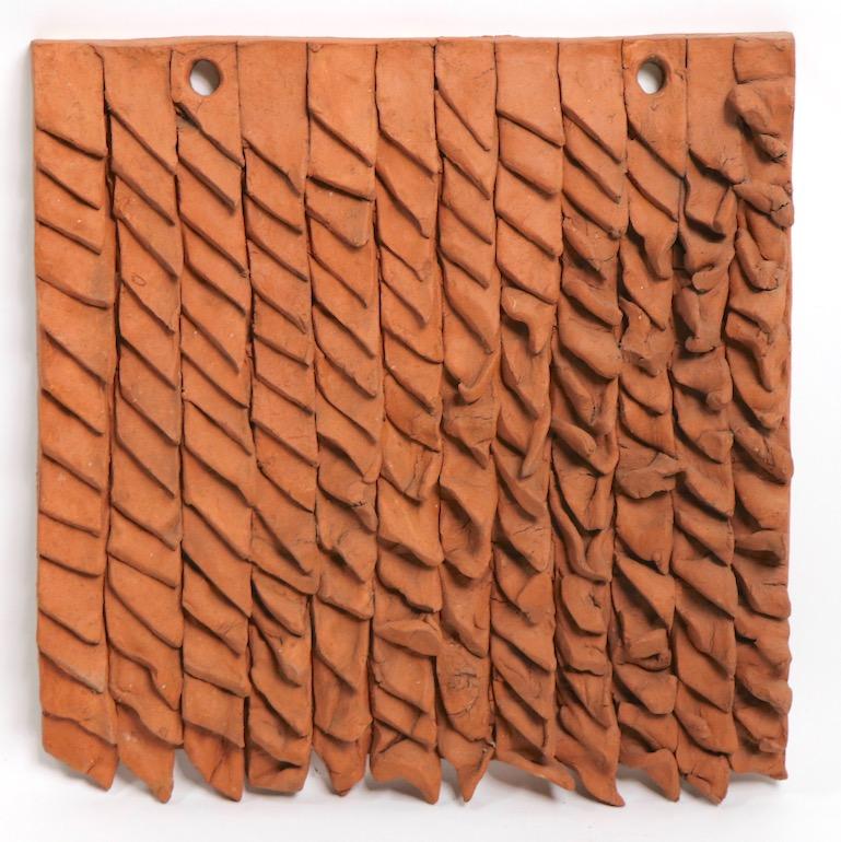Unusual Brutalist wall-mounted terra cotta sculpture by noted potter Claudia Reese, dated '75. Rare early example of her work, not often seen on the market, this sculpture incorporates an organic dimensional surface on a square ground.