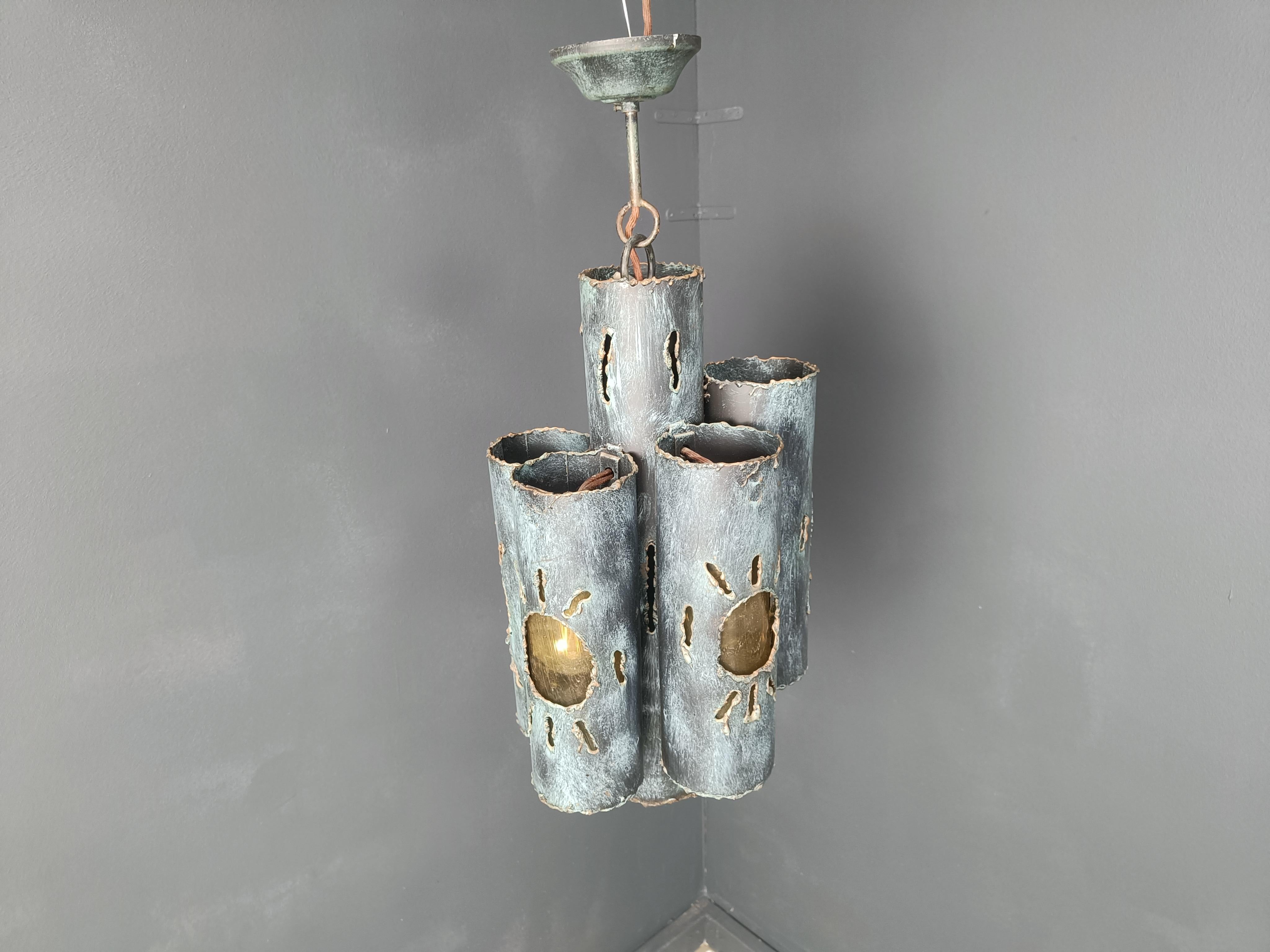 Striking brutalist pendant light with 5 lightpoints and orange glass.

Beautiful sculptured torch cut steel tubes with amber tinted glass which gives a nice warm glow. 

Tested and ready to use with a regular E14 light bulbs

1960s -