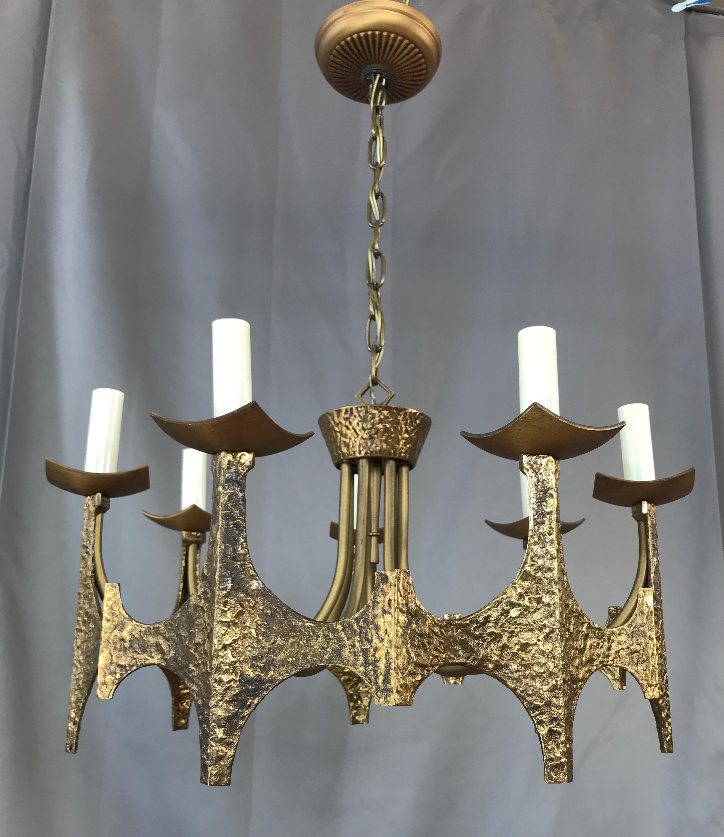 Offer here is a Brutalist chandelier By Moe lighting
From the original 1969 catalog:
A unique blending of the old and new worlds hand-hammered antique bronze forms a framework that is geometrically contemporary in execution.
This eclectic styling